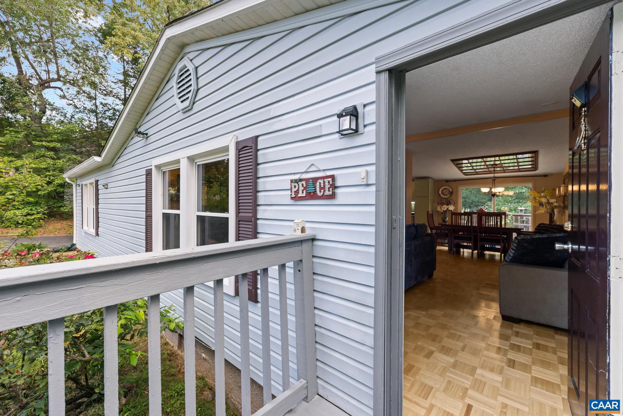 Step onto the welcoming front porch and into a bright, open living space! Featuring classic light siding and dark shutters outside, the entry opens directly to rich parquet floors and a warm, inviting floor plan. Ideal for effortless living!