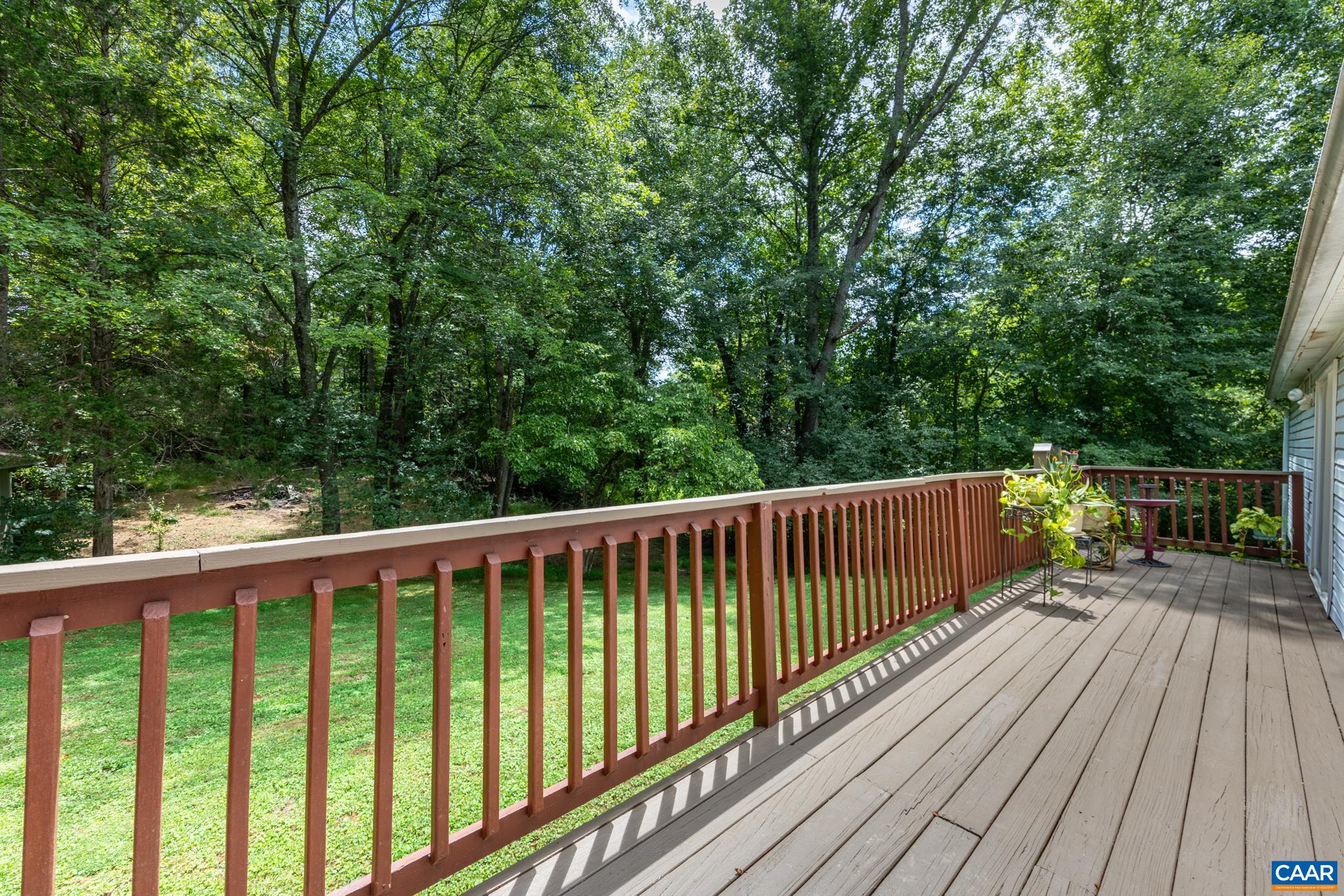 Unwind on this expansive back deck overlooking a tranquil, tree-lined yard! Featuring warm wood railings and composite decking, this private outdoor space offers plenty of room for grilling, dining, and taking in peaceful nature views.