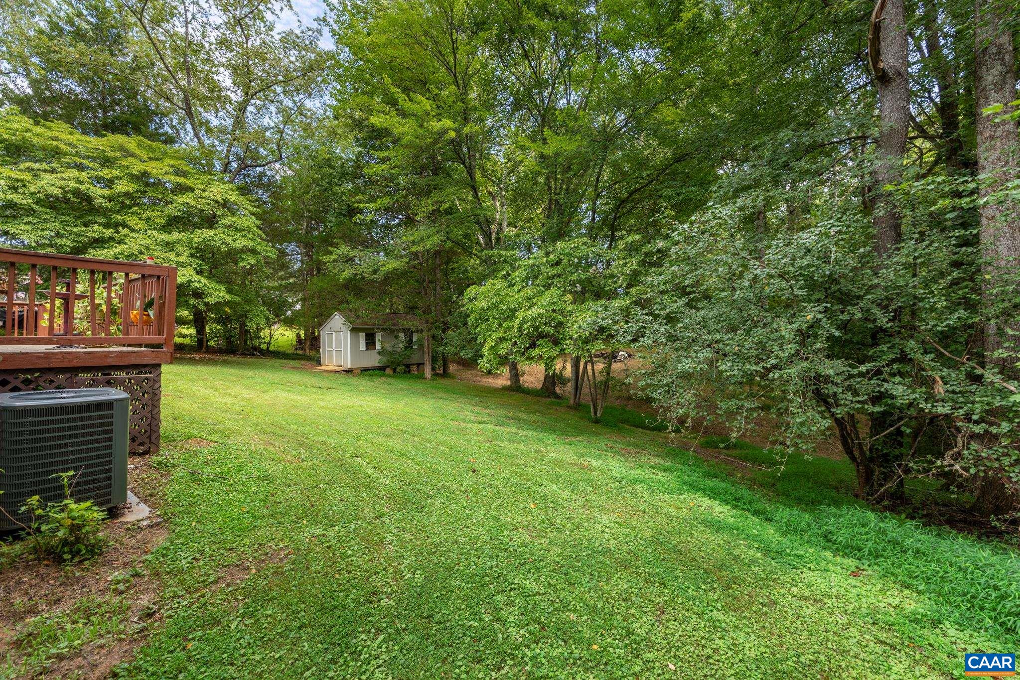 Expansive, lush backyard retreat surrounded by mature trees for maximum privacy! Features a charming storage shed, crisp lawn, and direct view of the raised rear deck. A beautiful, peaceful space for outdoor activities, gardening, and play!
