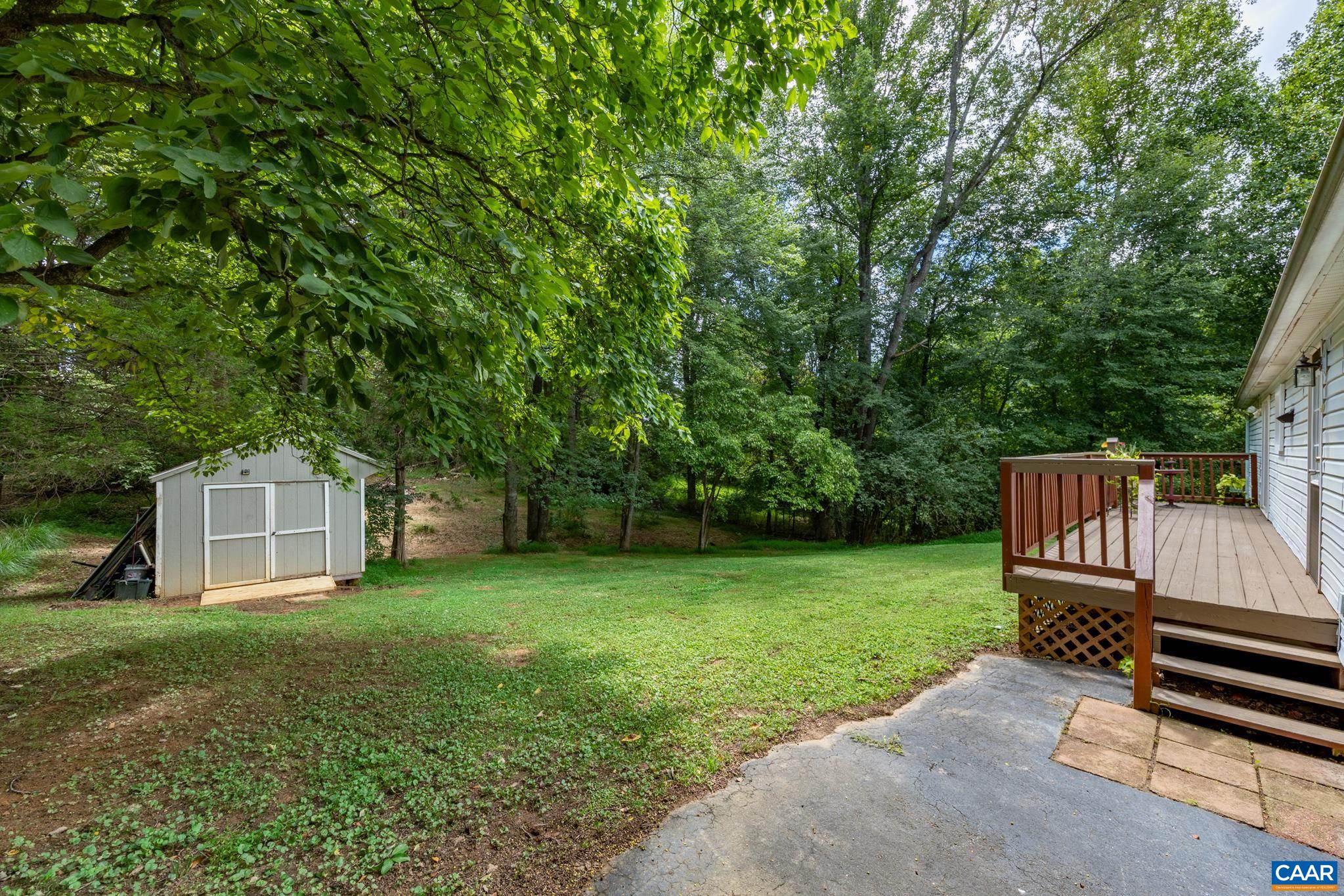 Private back patio and deck area opening to a lush, sprawling lawn! Complete with a helpful storage shed and surrounded by mature shade trees, this secluded backyard oasis offers endless possibilities for outdoor recreation and relaxation.
