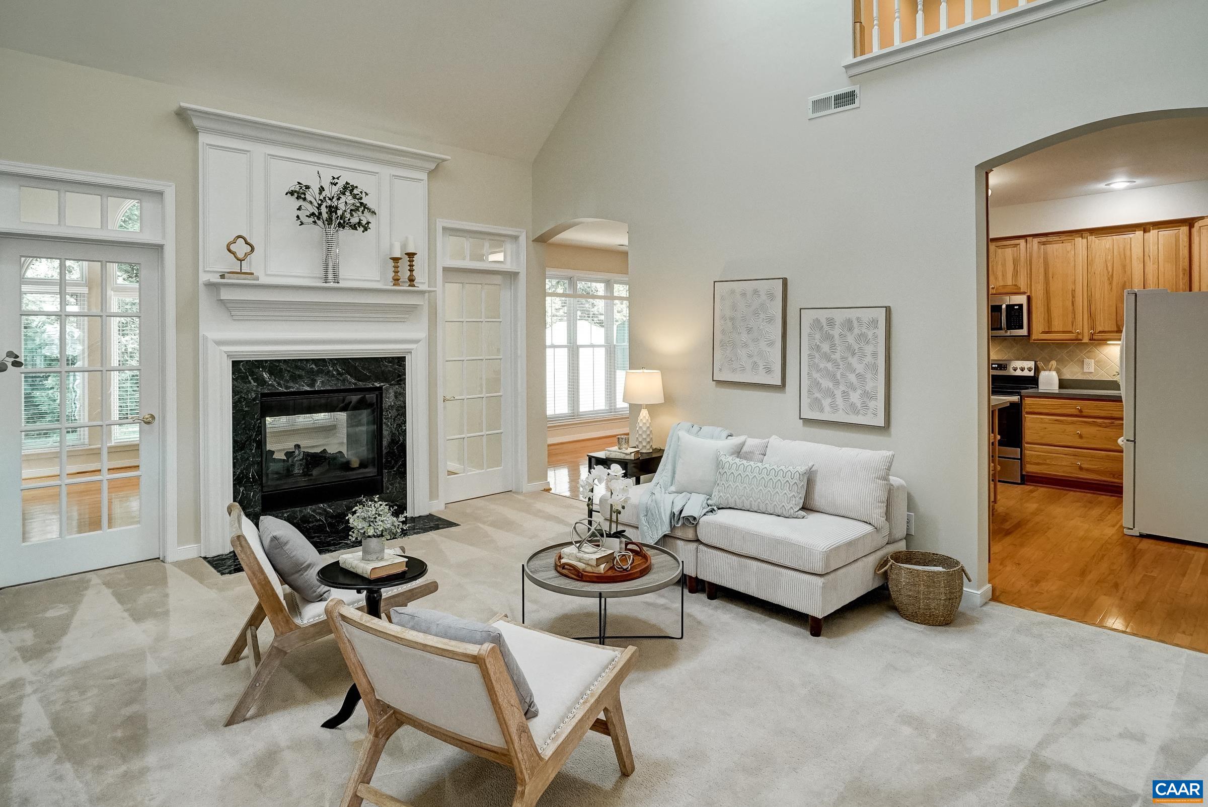 Two story great room features a ceiling fan and two-sided gas fireplace. Two story great room features a ceiling fan and two-sided gas fireplace.