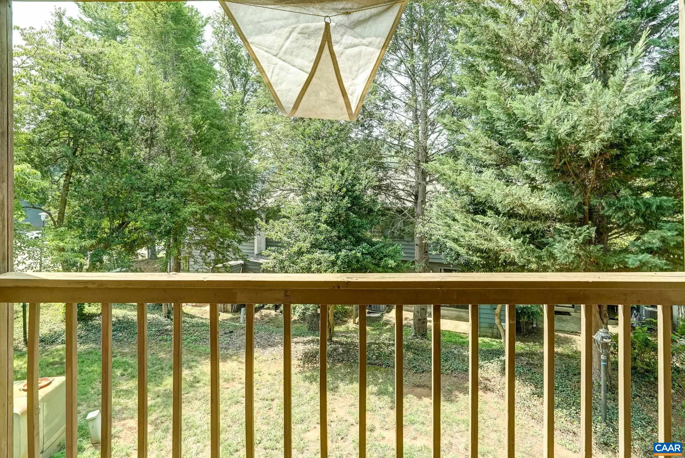 Covered balcony overlooks treelined area. Covered balcony overlooks treelined area.