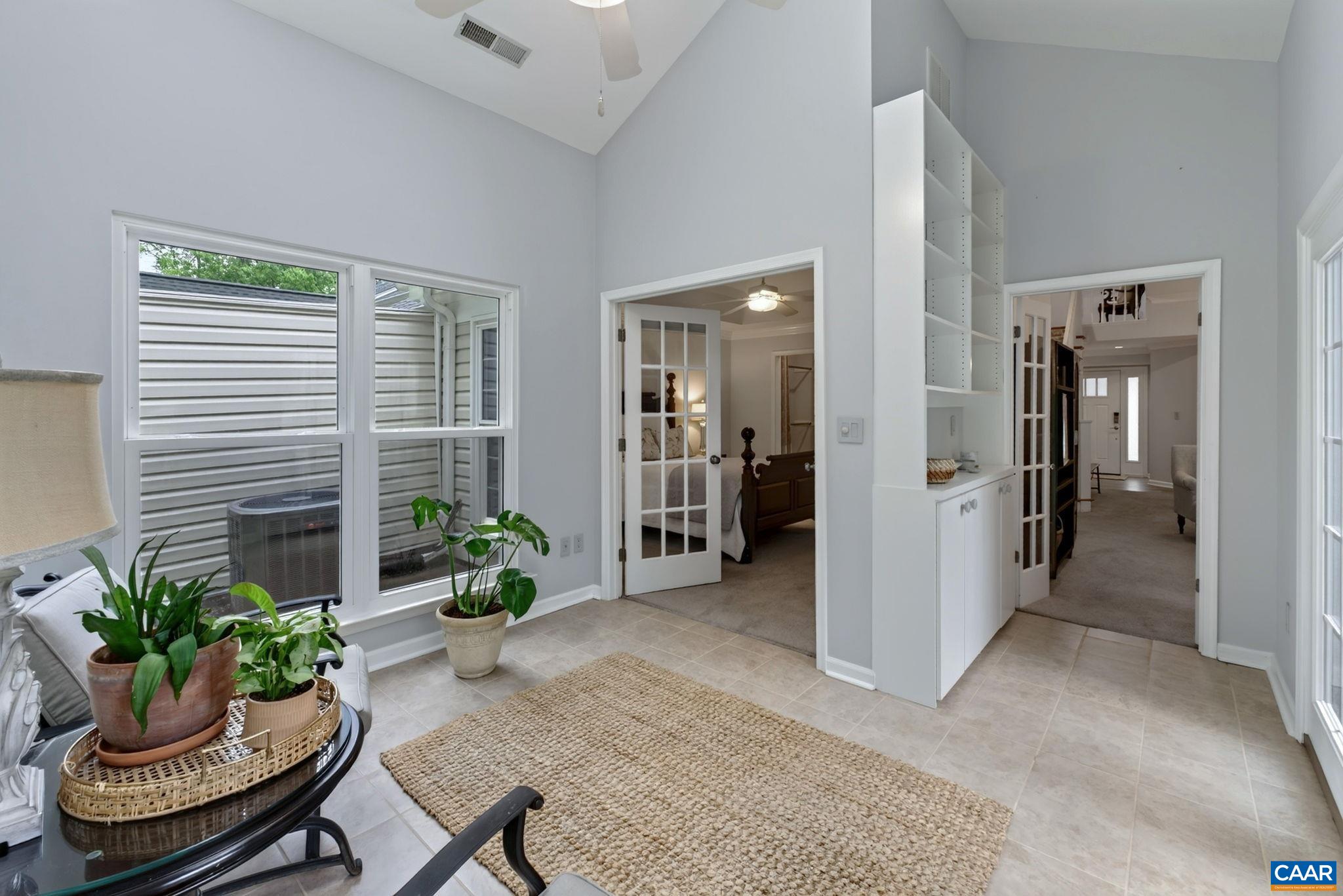 Sunroom is well appointed with French doors, high vaulted ceiling, tile flooring and built-in bookcases Sunroom is well appointed with French doors, high vaulted ceiling, tile flooring and built-in bookcases