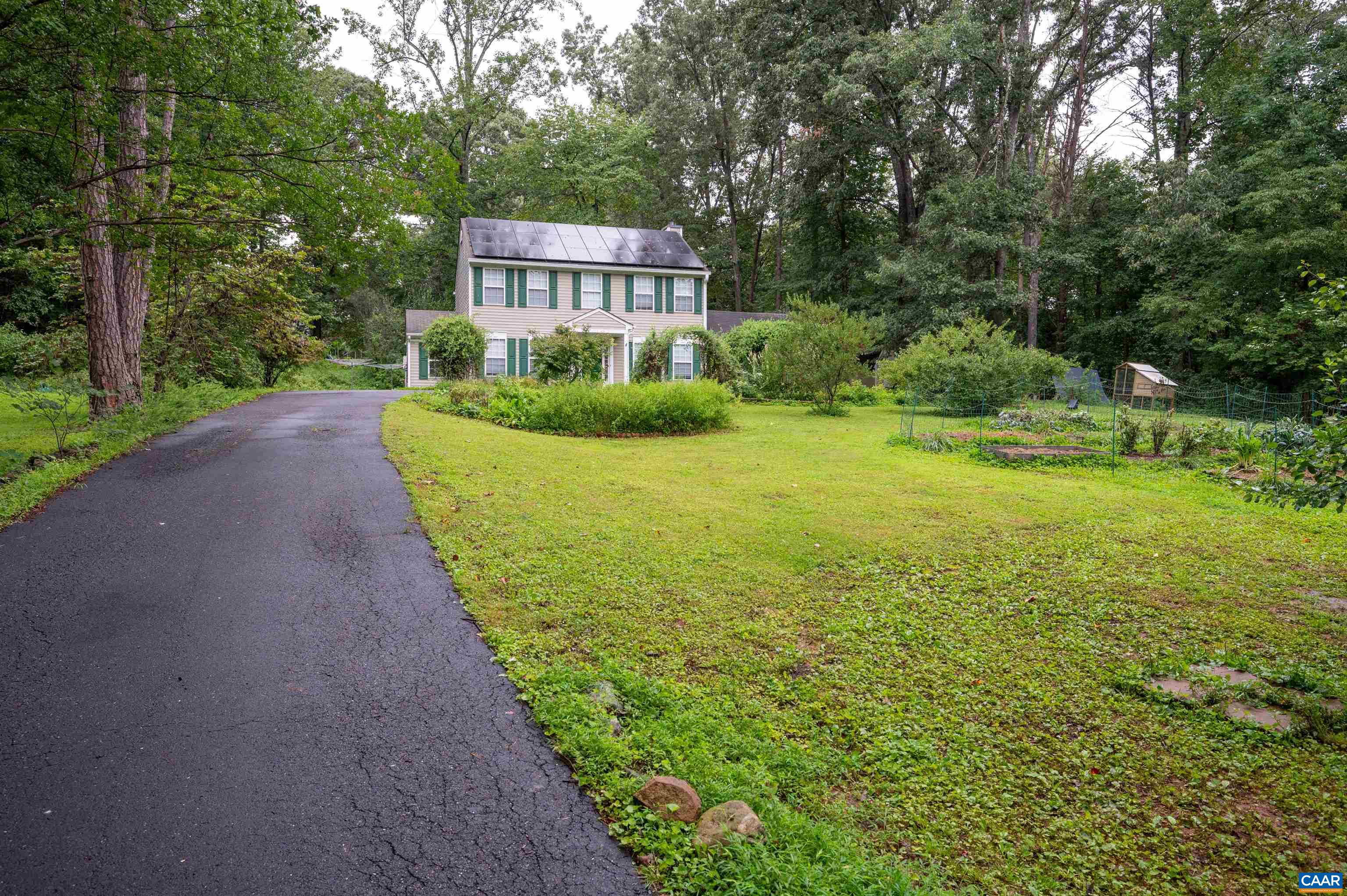 The expansive front yard features many gardens.