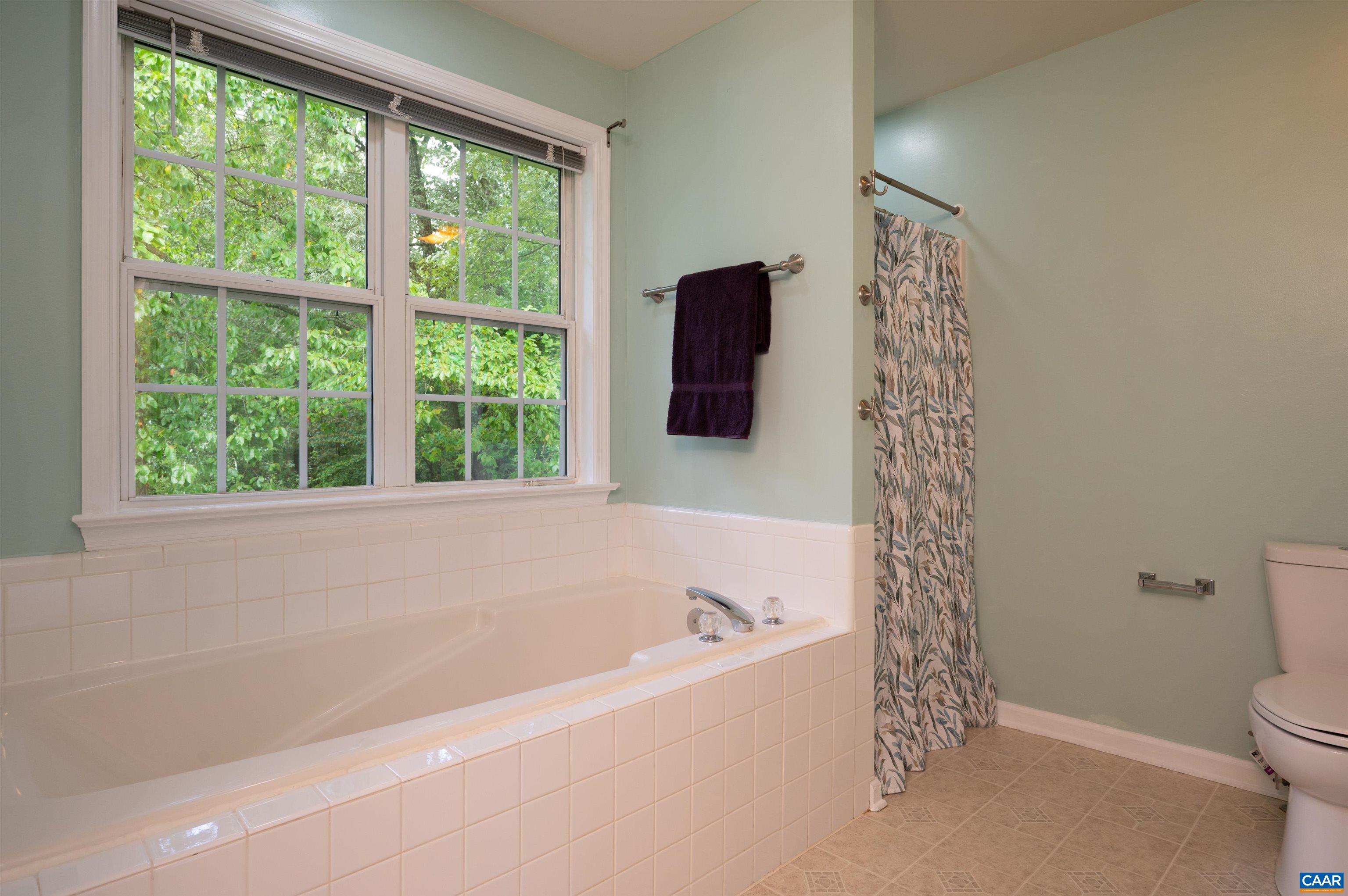 Light filled, spacious primary bath with garden tub and separate shower.