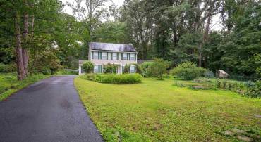 The expansive front yard features many gardens.