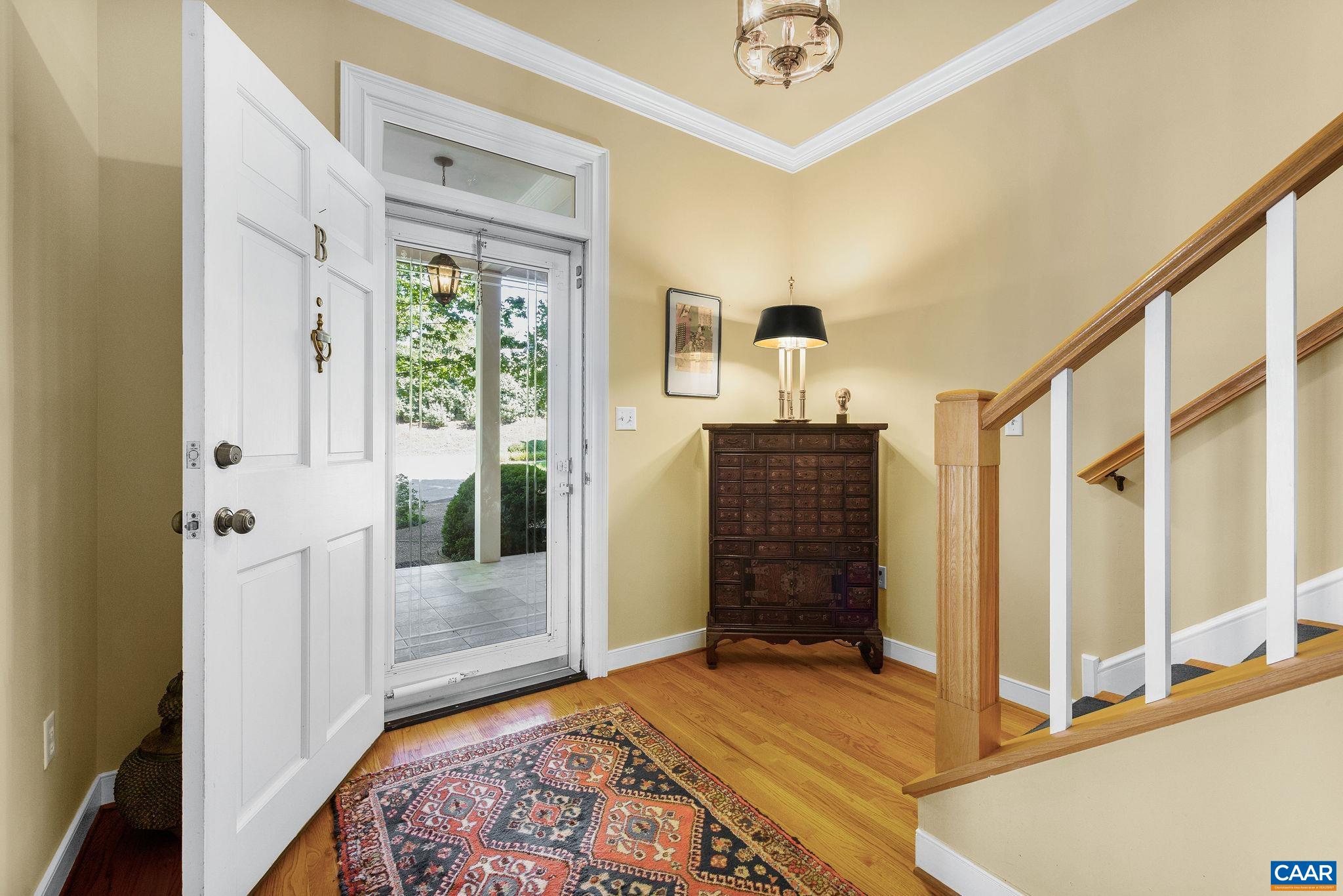 Inviting, open foyer with hardwood floors and chandelier.