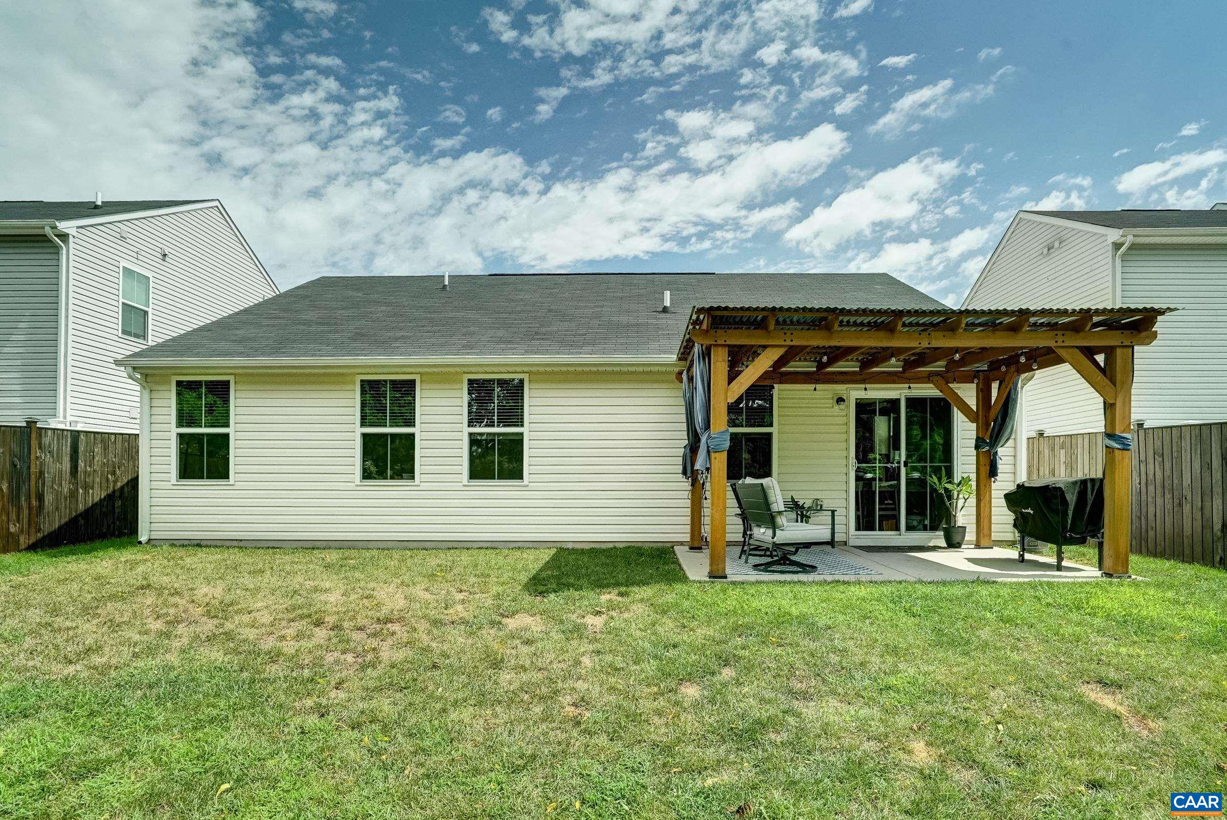 Flat back yard features privacy fence and covered patio with roofed pergola Flat back yard features privacy fence and covered patio with roofed pergola