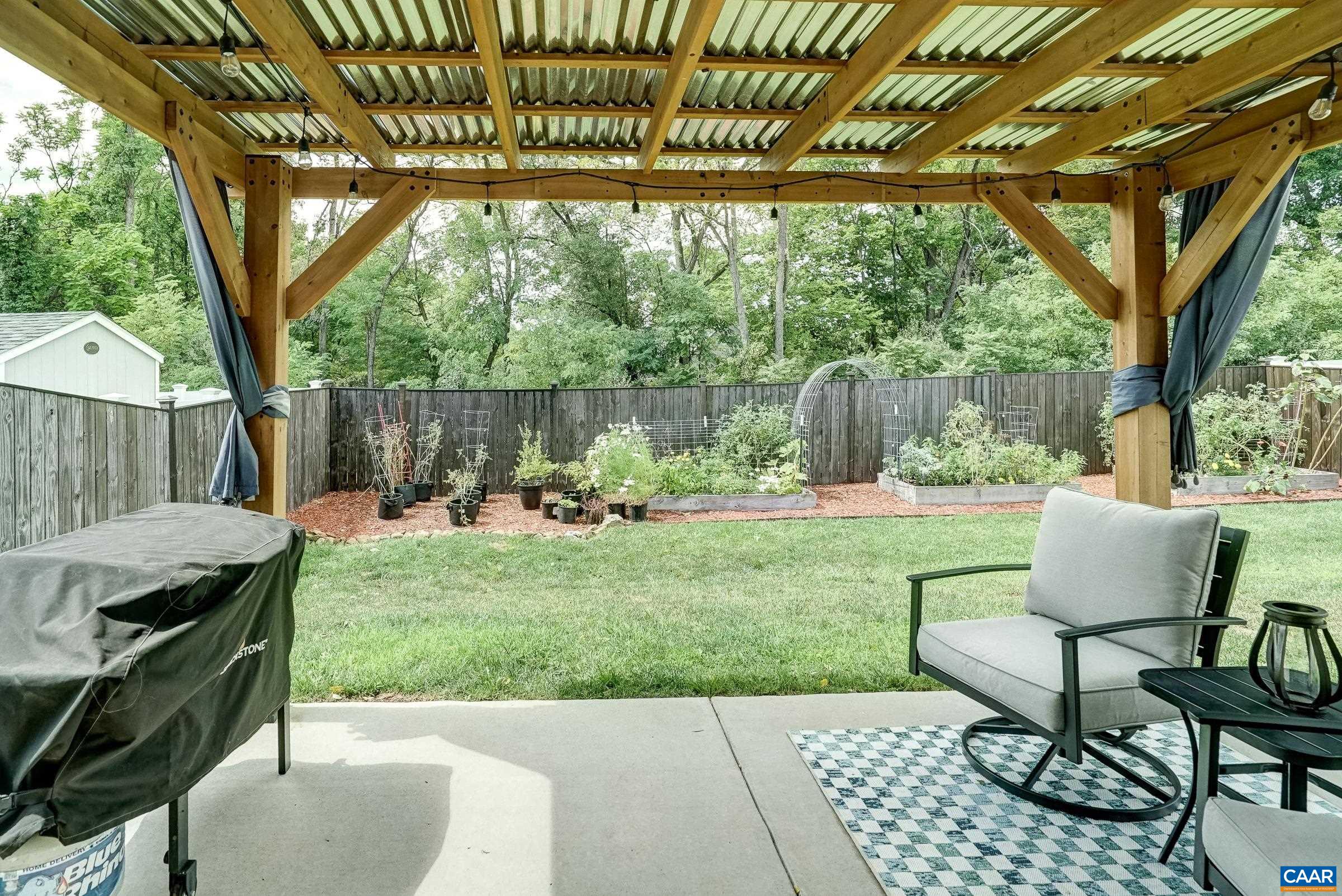 Covered patio features cedar pergola with corrugated metal roof. Covered patio features cedar pergola with corrugated metal roof.