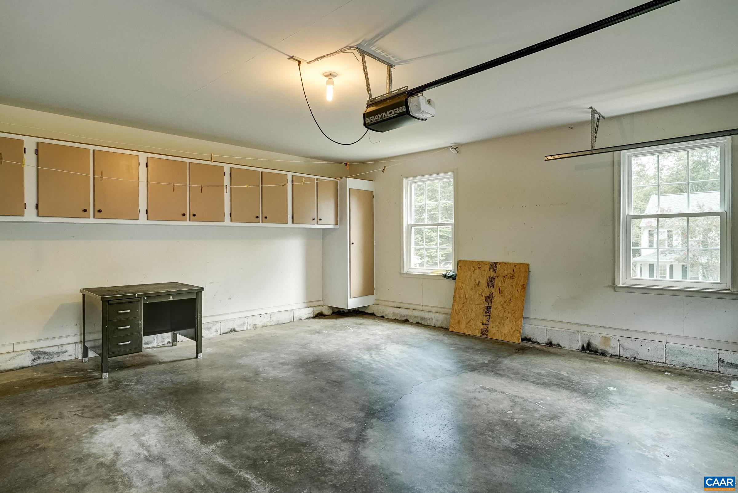 Large garage features storage cabinets and desk. Large garage features storage cabinets and desk.