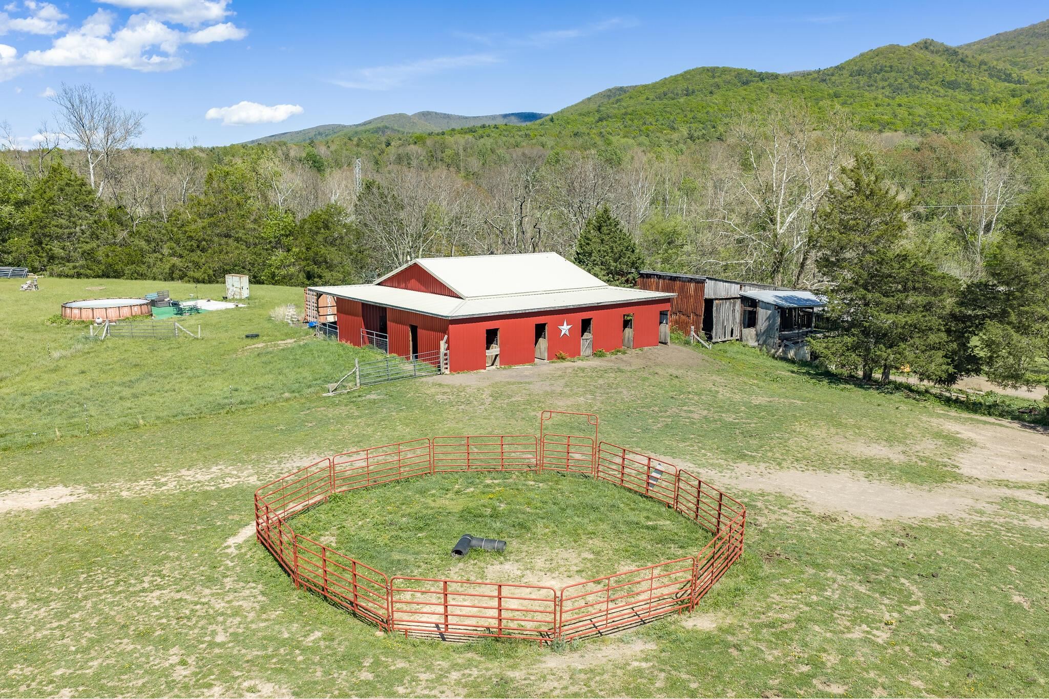 Two barns provide substantial infrastructure: a newer 60’ x 60’ barn featuring 8 stalls (with potential to expand to 10–12), open interior space, and room for trailer storage. Two barns provide substantial infrastructure: a newer 60’ x 60’ barn featuring 8 stalls (with potential to expand to 10–12), open interior space, and room for trailer storage.