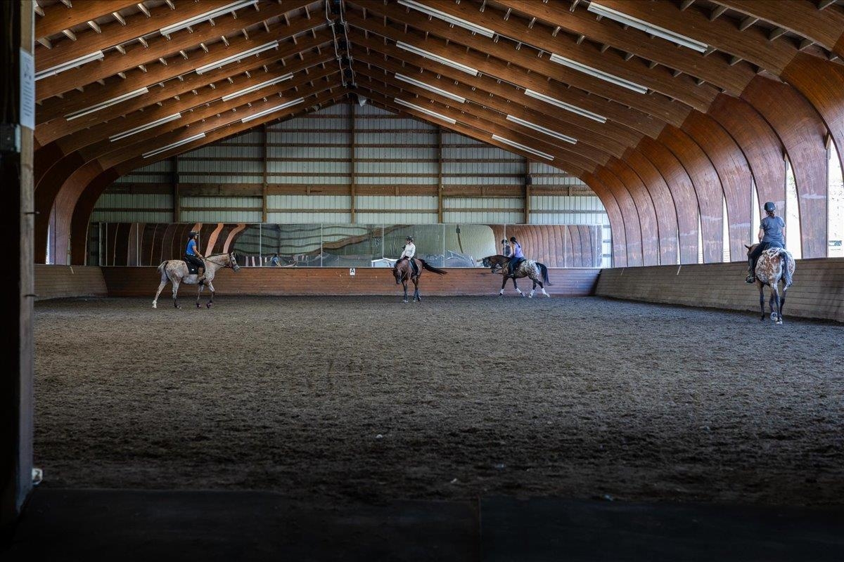 Approximately 14,400 sq. ft., with an additional 4' overhang. Constructed in 2005, the arena features a laminated wood beam structure with aluminum siding along one long wall and one end wall. The riding surface consists of crusher run/sand/Trutex Approximately 14,400 sq. ft., with an additional 4' overhang. Constructed in 2005, the arena features a laminated wood beam structure with aluminum siding along one long wall and one end wall. The riding surface consists of crusher run/sand/Trutex