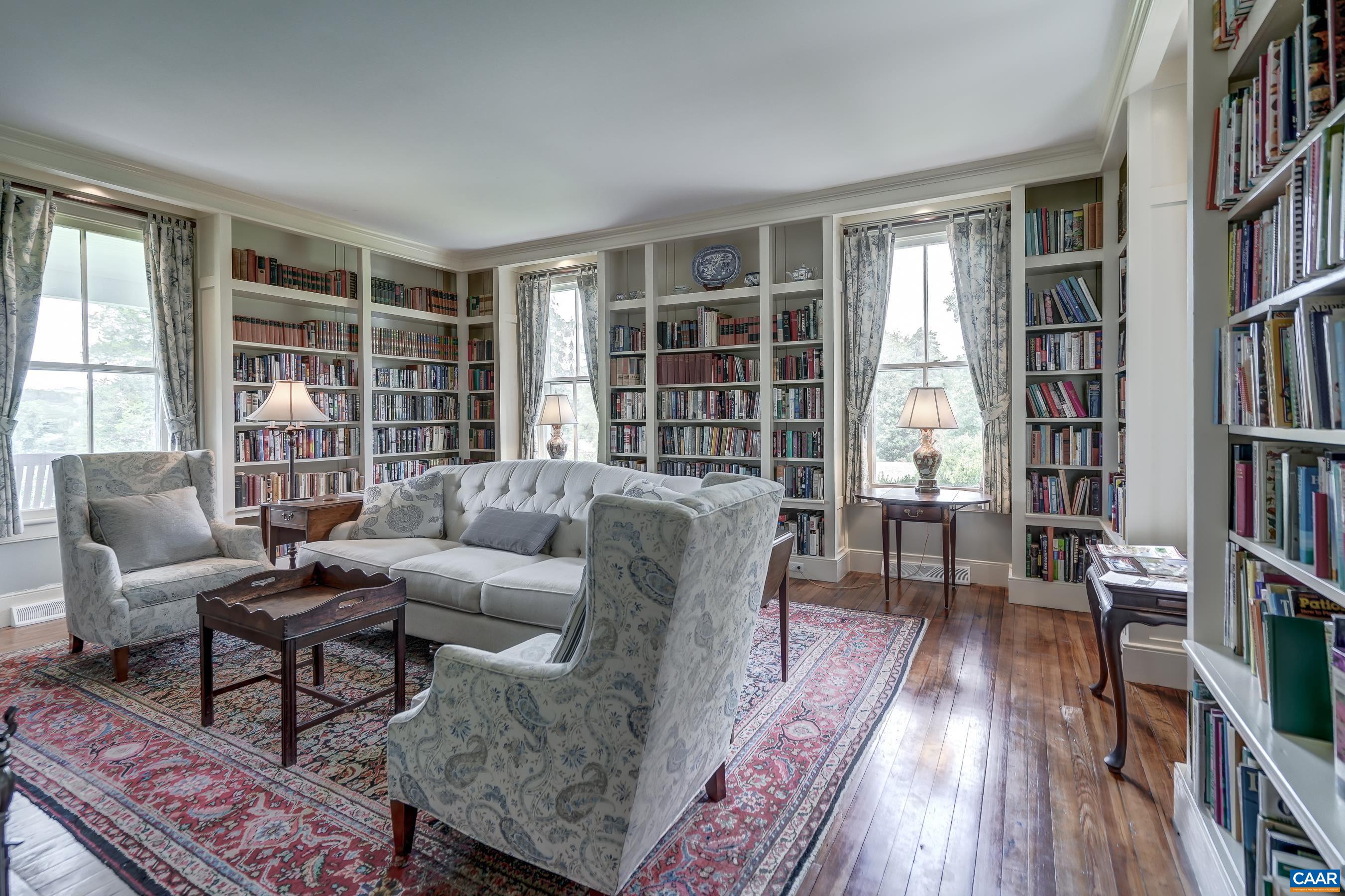 Cozy library features built-in shelves and a wood burning fireplace