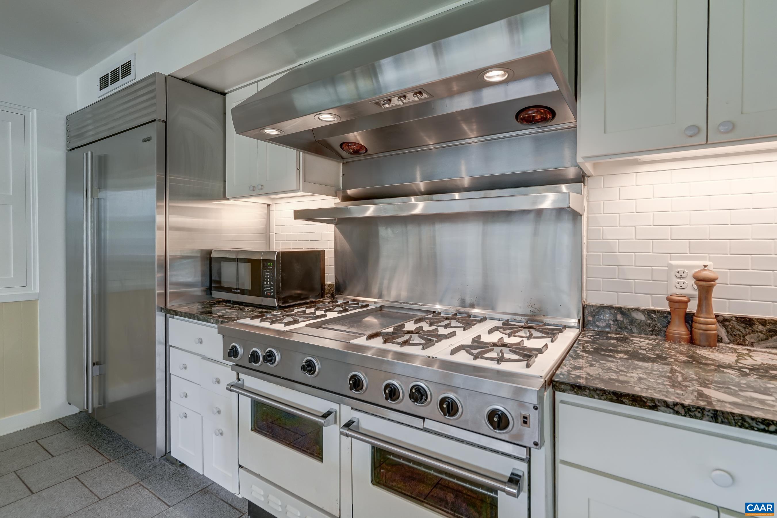 Commercial range with double ovens and gas cooktop.