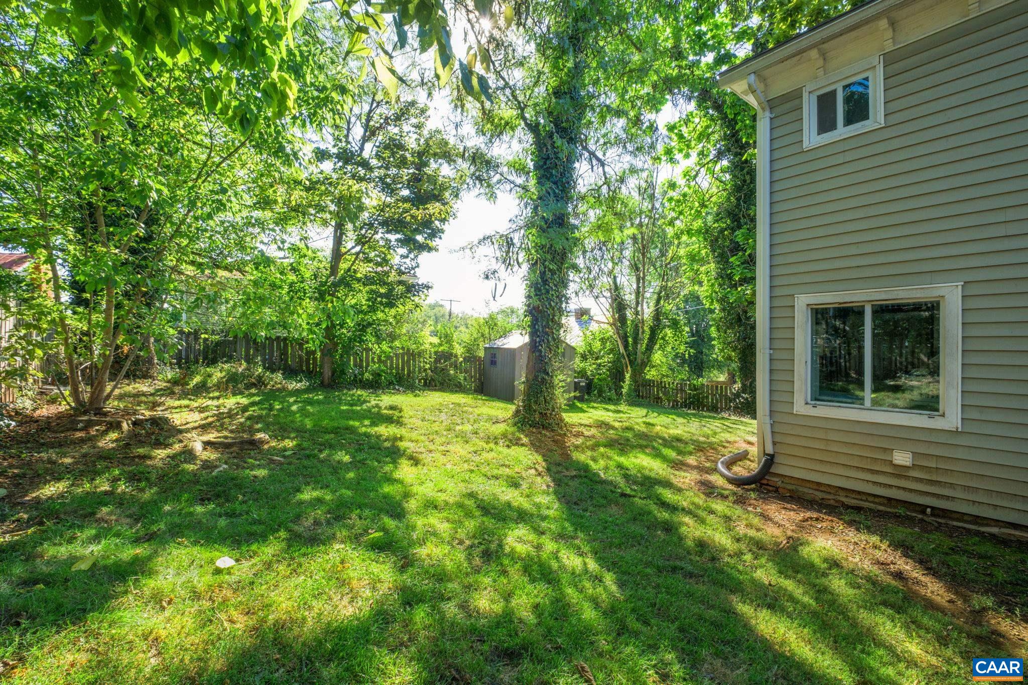 Shady fenced back yard with storage shed. Shady fenced back yard with storage shed.