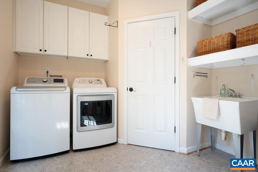 Laundry sink, cabinetry, closet and shelving help to make this space extremely functional and organized