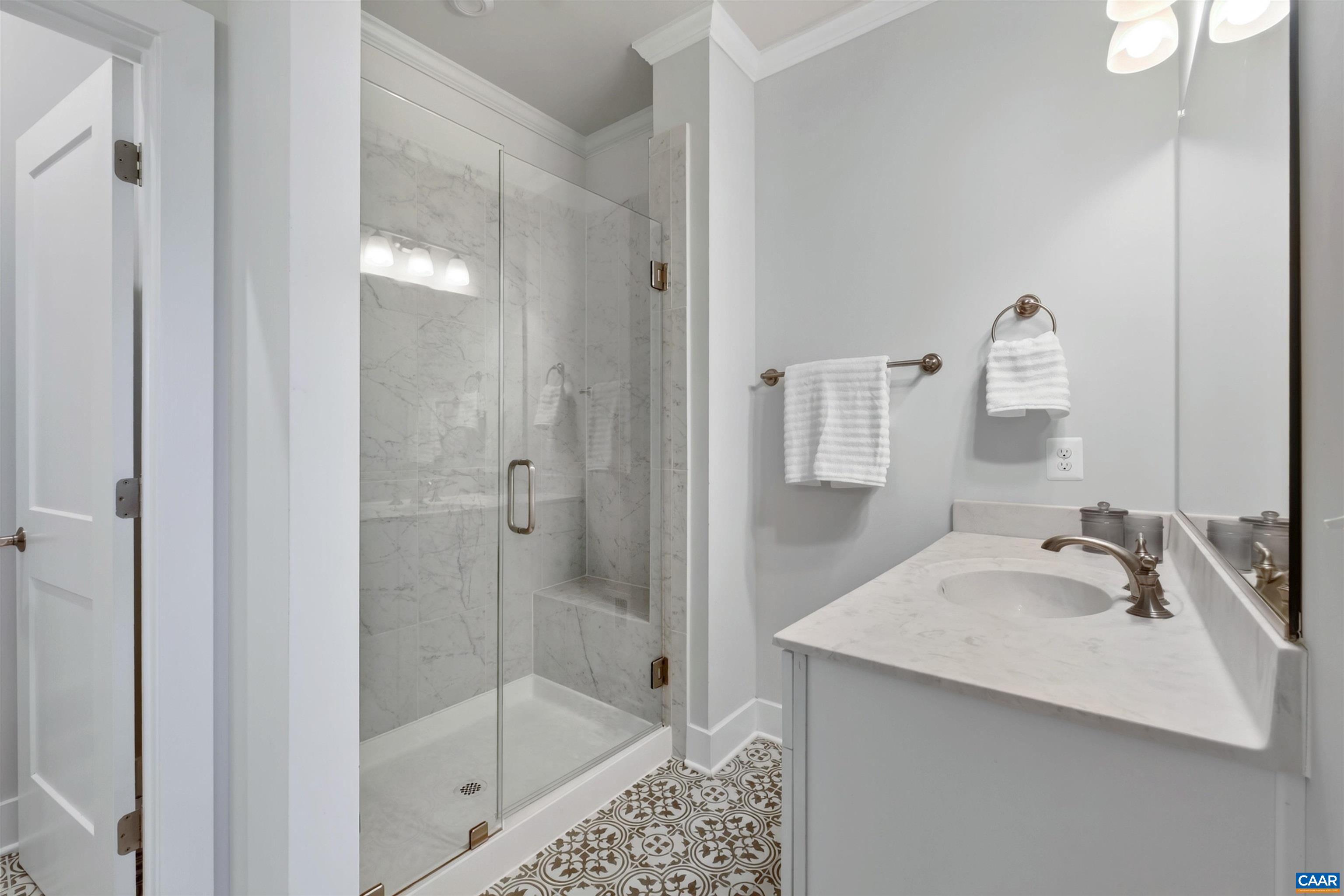 Primary bath offers dual vanities, water closet, and gorgeous tiled shower with bench seating