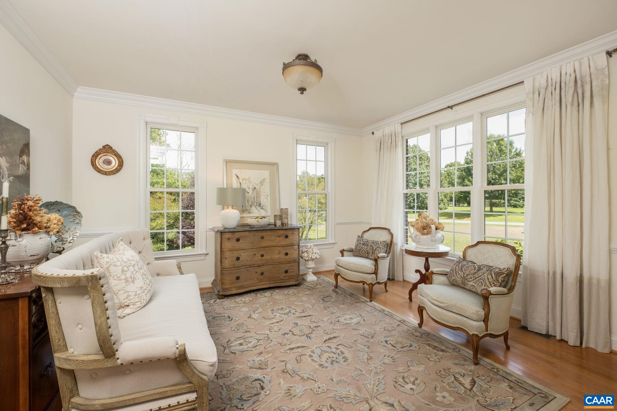 Sitting room features hardwood floors, crown molding, and chair railing. Sitting room features hardwood floors, crown molding, and chair railing.