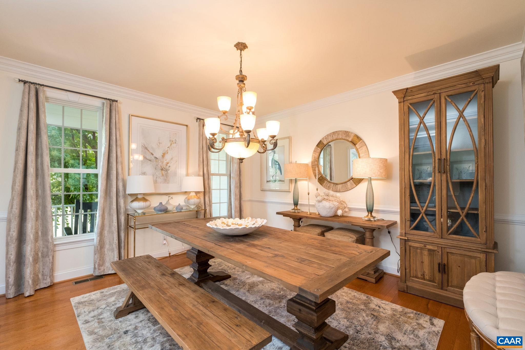 The dining room is spacious, with room for a good sized table, side tables, and a hutch. The dining room features crown molding and chair railing. The dining room is spacious, with room for a good sized table, side tables, and a hutch. The dining room features crown molding and chair railing.