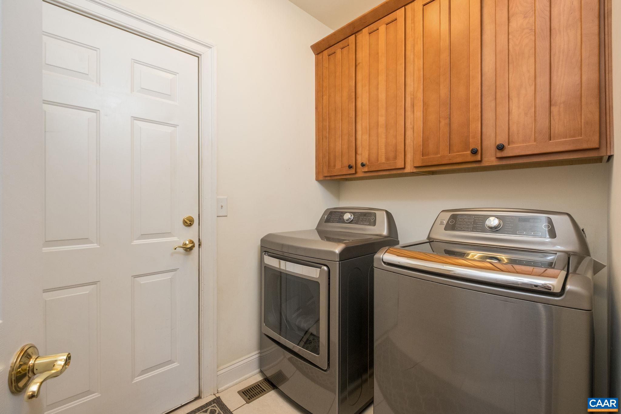 The laundry room features cherry cabinetry and shelving, and is located off of the garage. The laundry room features cherry cabinetry and shelving, and is located off of the garage.