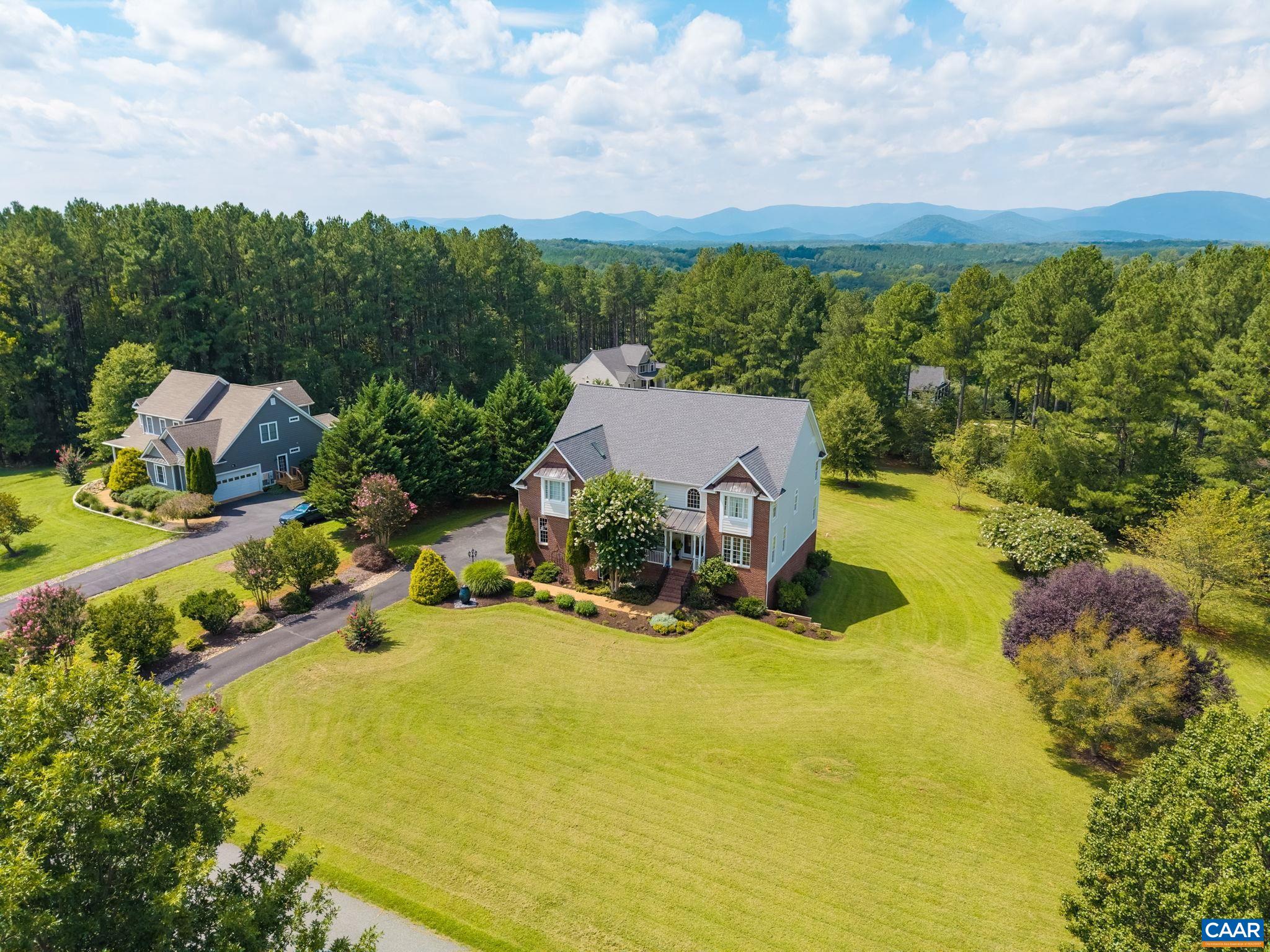 This picture brings you closer to the property. The lawn features mature trees and a water fountain in the front corner by the driveway. This picture brings you closer to the property. The lawn features mature trees and a water fountain in the front corner by the driveway.