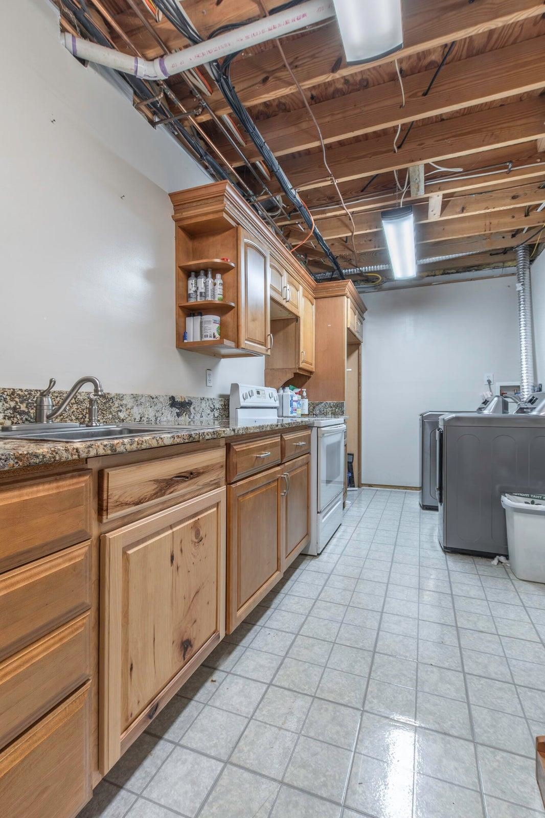 Full kitchen with quartz countertops. Currently serves as Laundry/Utility Room Full kitchen with quartz countertops. Currently serves as Laundry/Utility Room