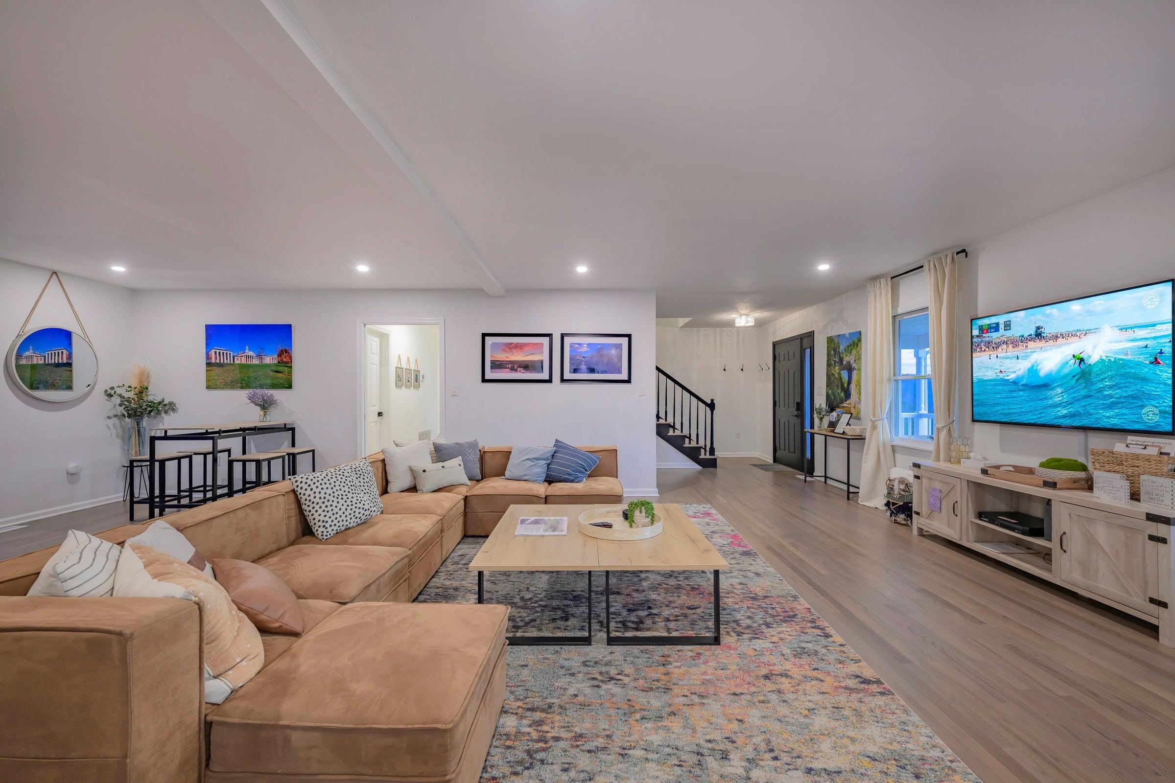 Large open living room. Gracious furniture. Screen for movies or TV.