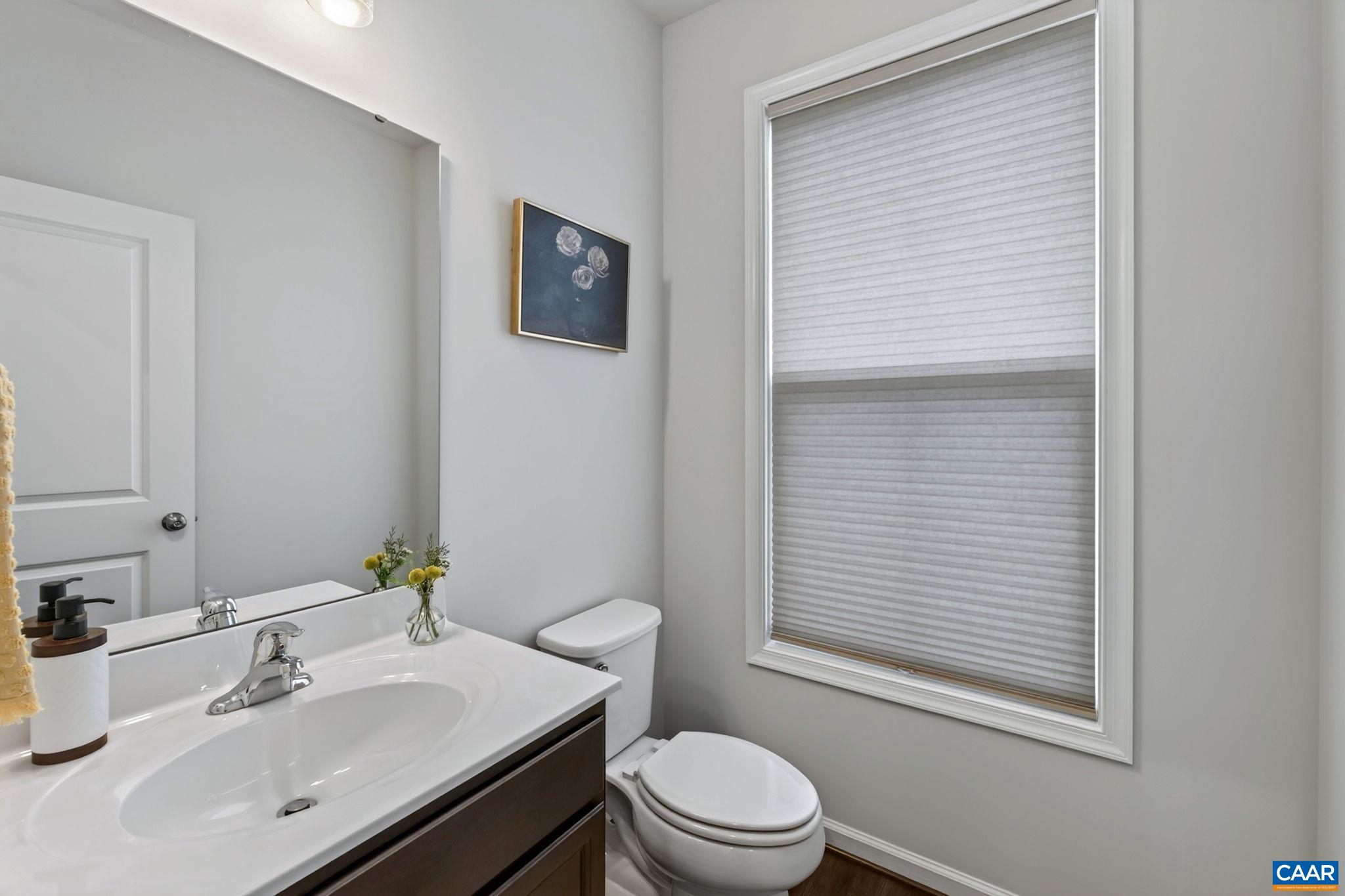 The 1/2 bath is thoughtfully tucked off of the main living area The 1/2 bath is thoughtfully tucked off of the main living area