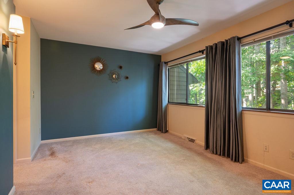 Primary bedroom has large picture windows overlooking the back yard and trees beyond Primary bedroom has large picture windows overlooking the back yard and trees beyond