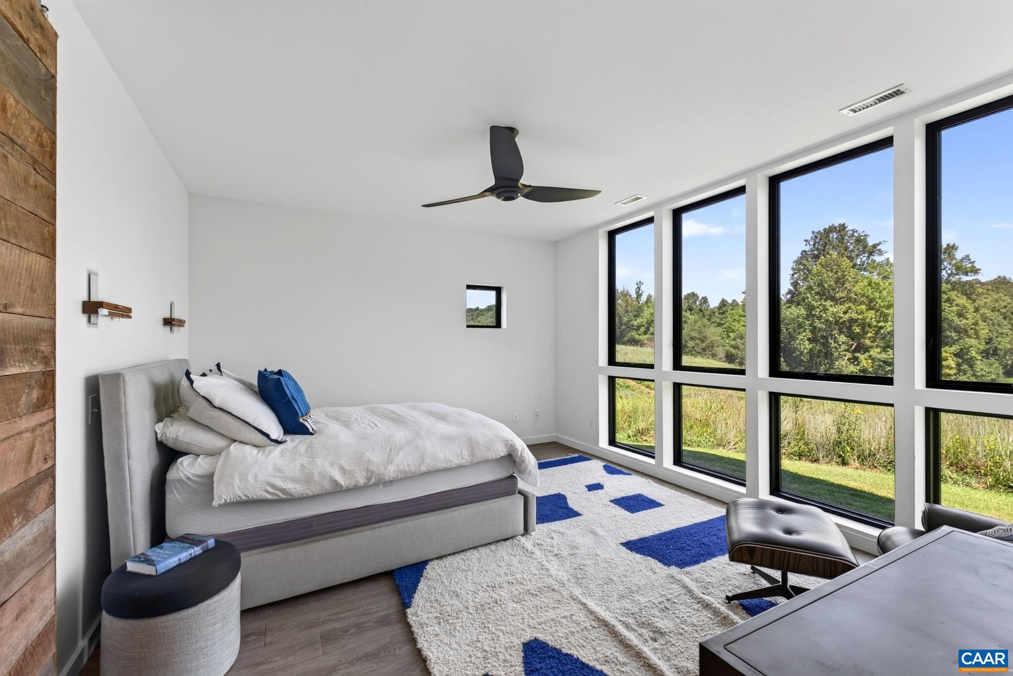 Primary bedroom with a wall of windows. Primary bedroom with a wall of windows.