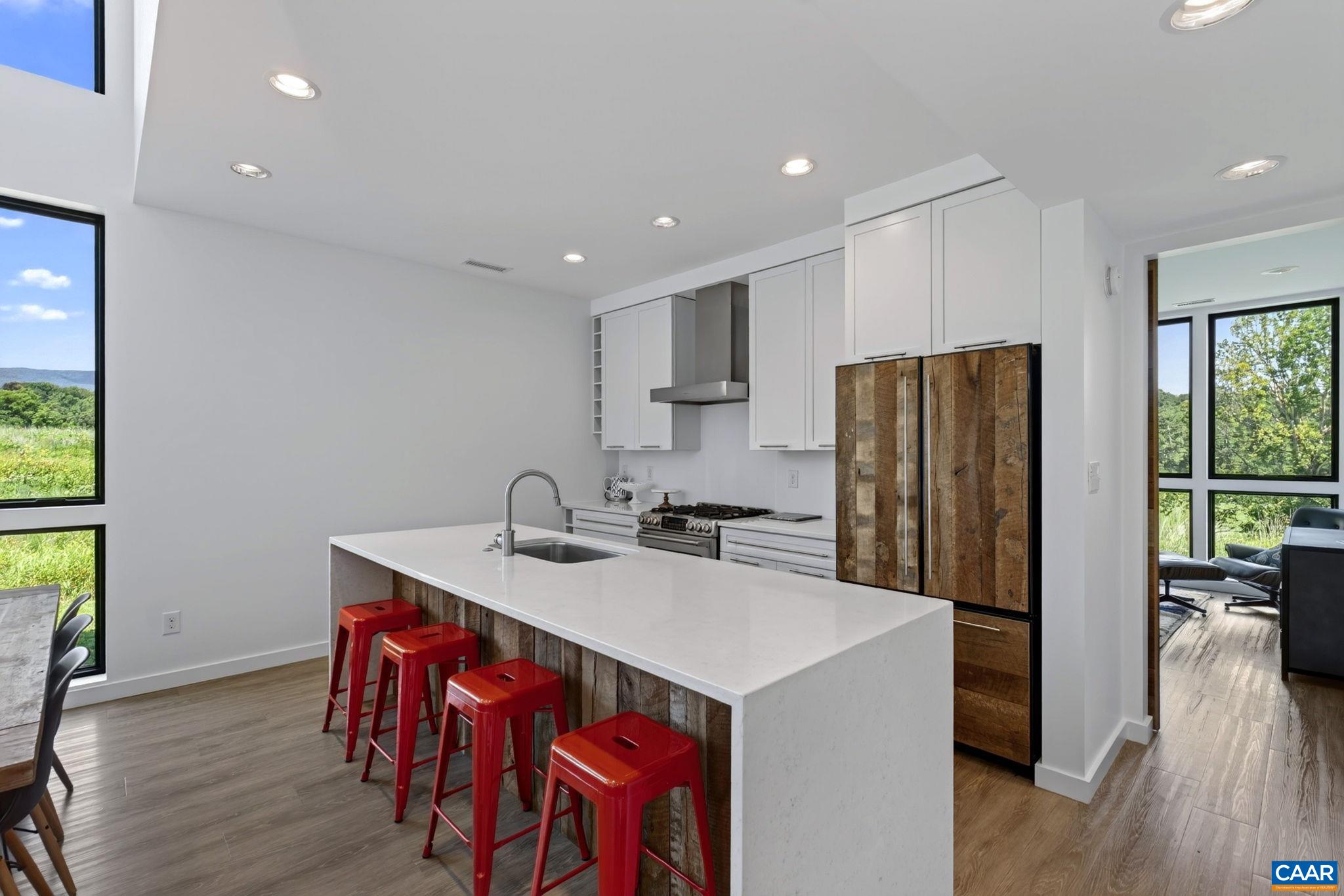 Stainless kitchen with quartz counters, eating island and rough hewn wood accents. Stainless kitchen with quartz counters, eating island and rough hewn wood accents.