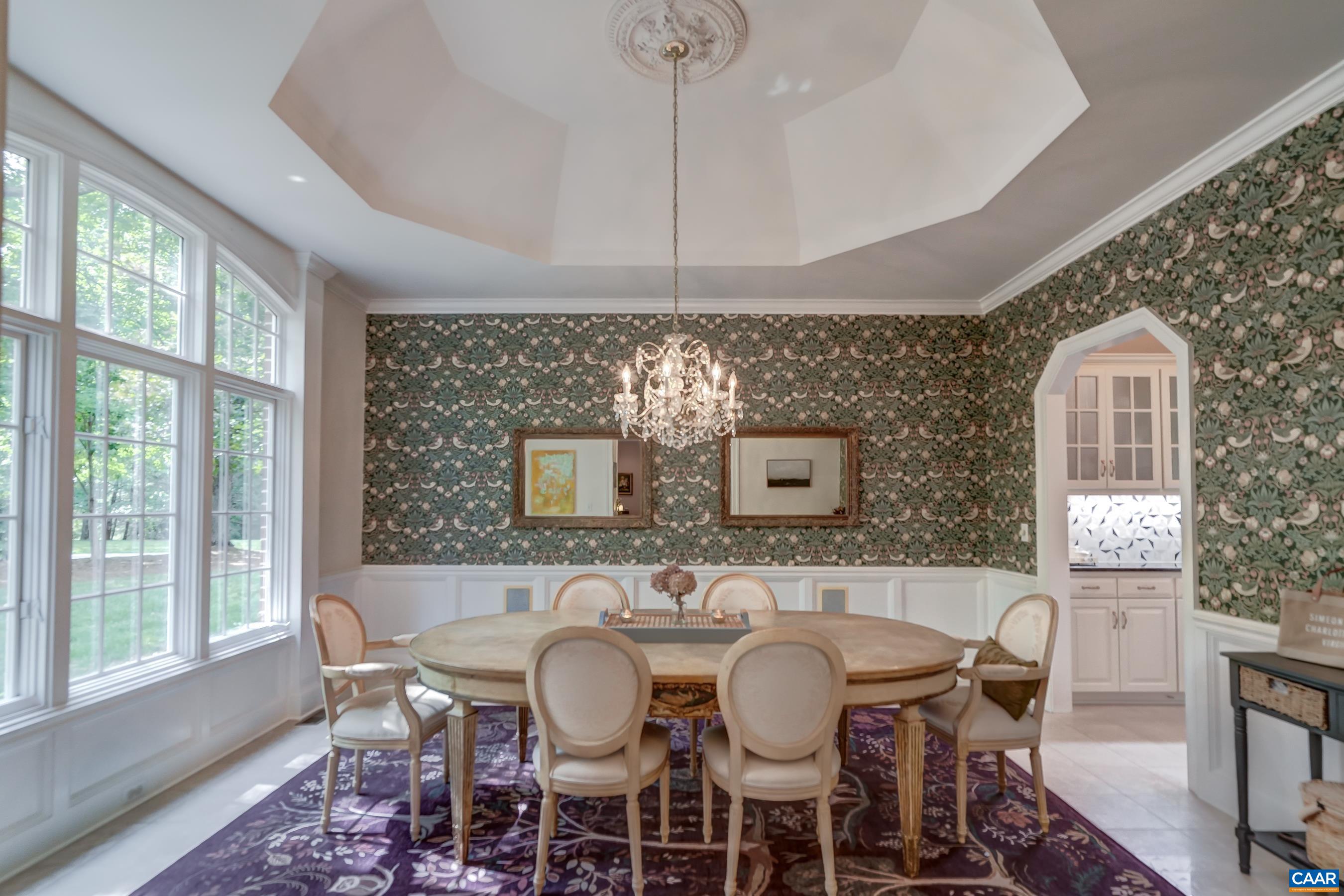 Formal dining room features custom wall coverings, bay window, and statement chandelier Formal dining room features custom wall coverings, bay window, and statement chandelier