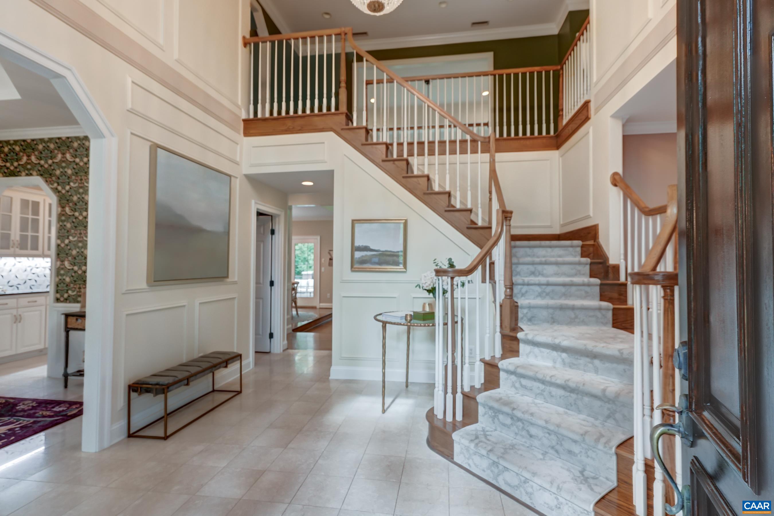Grand foyer with marble flooring and graceful curved staircase. Grand foyer with marble flooring and graceful curved staircase.
