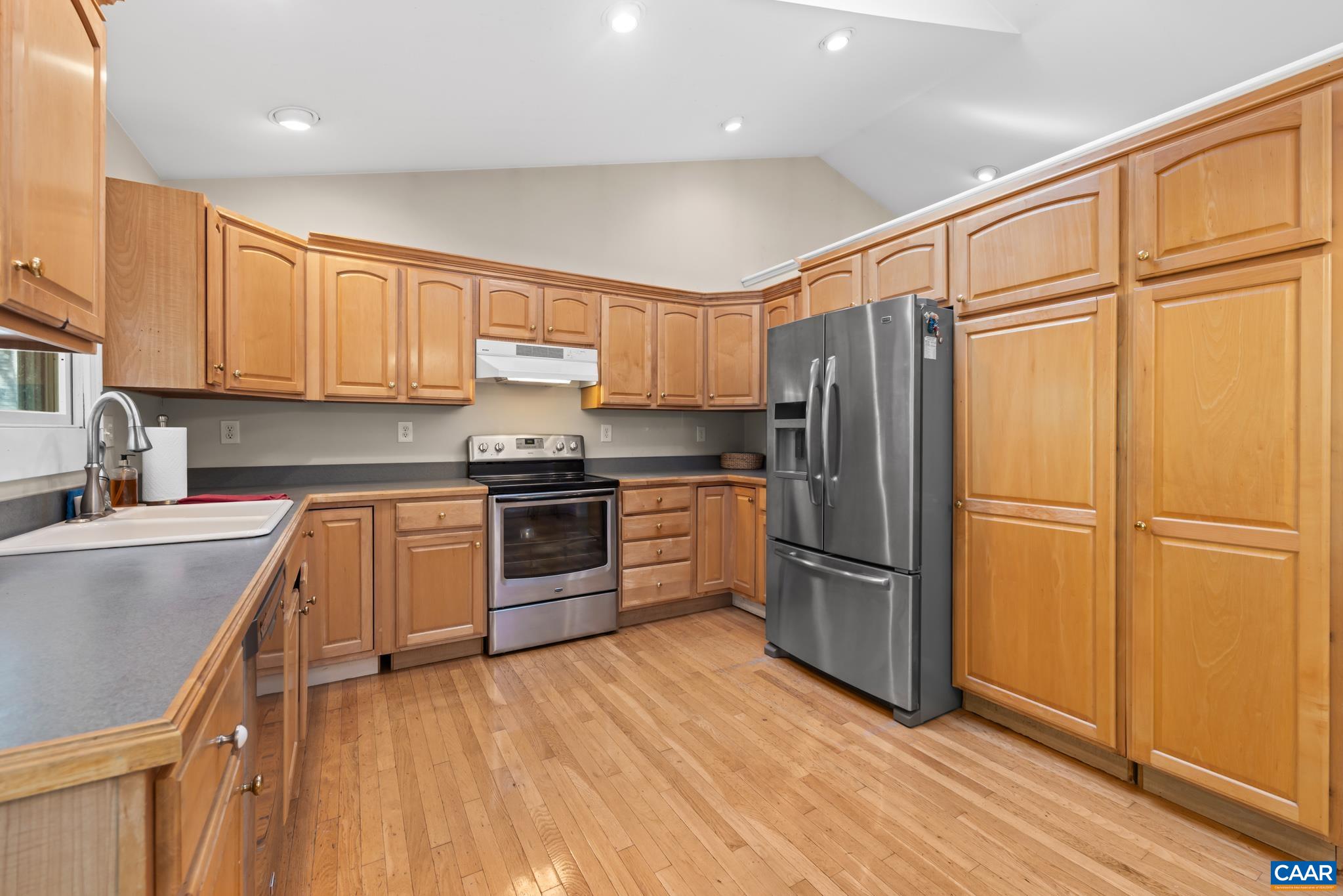 Sun filled kitchen featuring beautiful maple cabinetry and abundance of storage space for the cook in you.