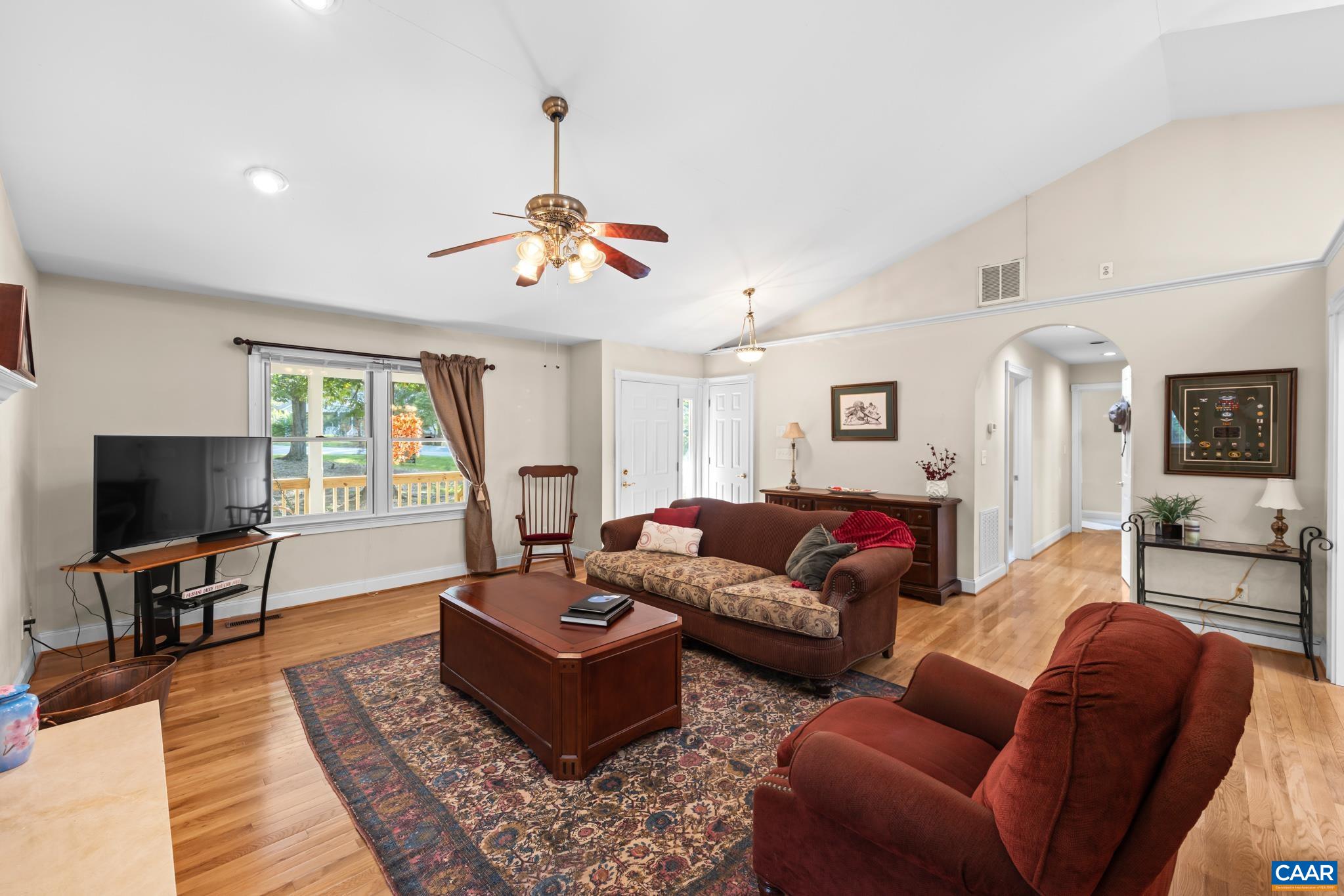 Spacious living room featuring beautiful hardwood floors, a cozy gas fireplace along with soaring ceilings. Generously sized to comfortably accommodate large gatherings. This space is perfect for entertaining.