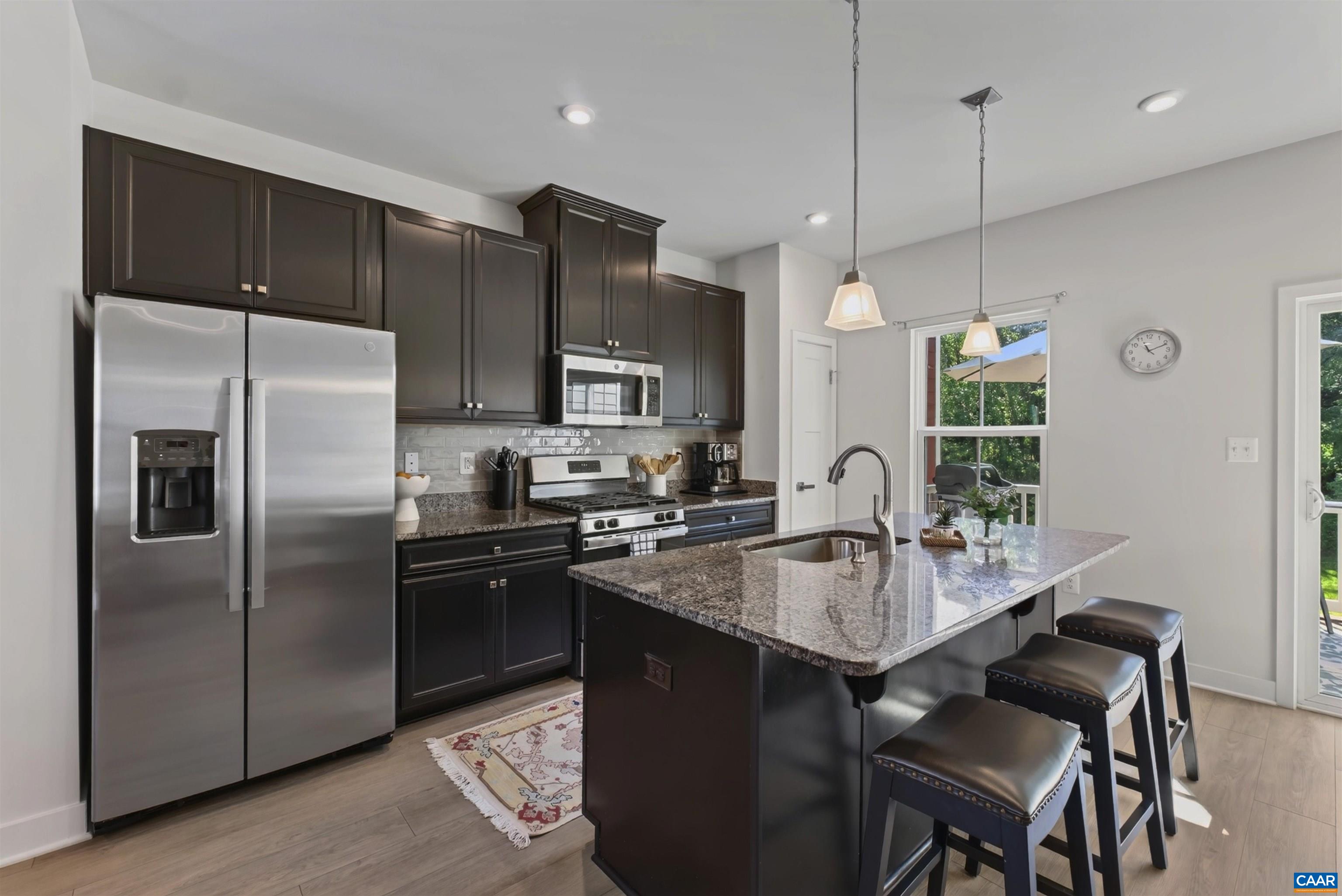 Kitchen features gas cooking with overhead vent to exterior