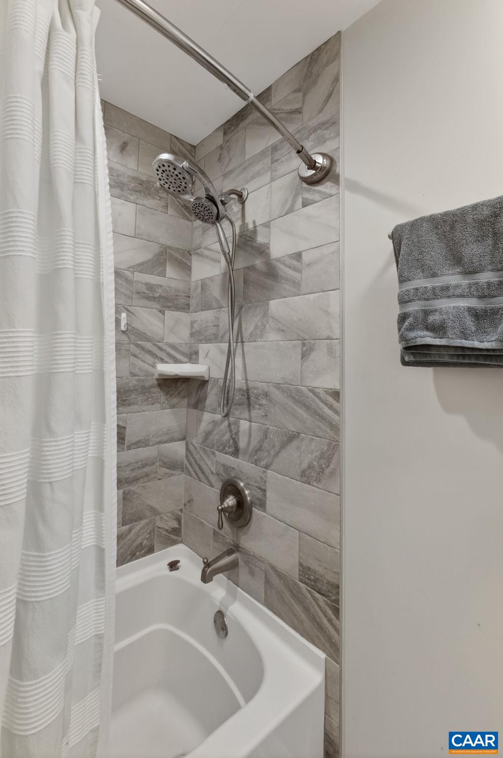 Tiled hall bathroom with tub.