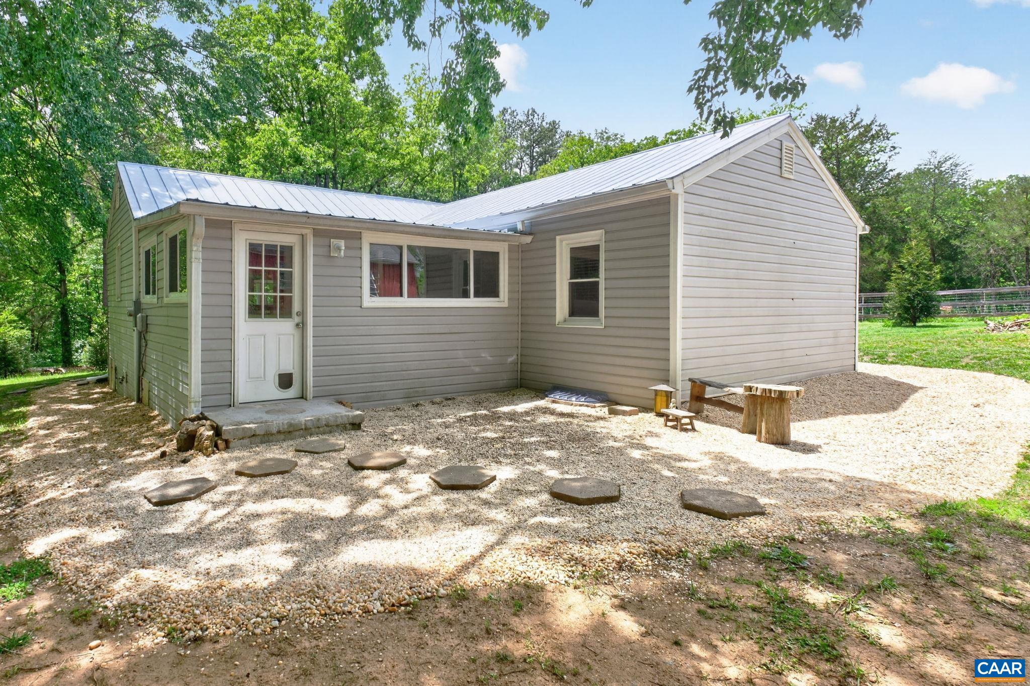Rear of home with small gravel patio area.