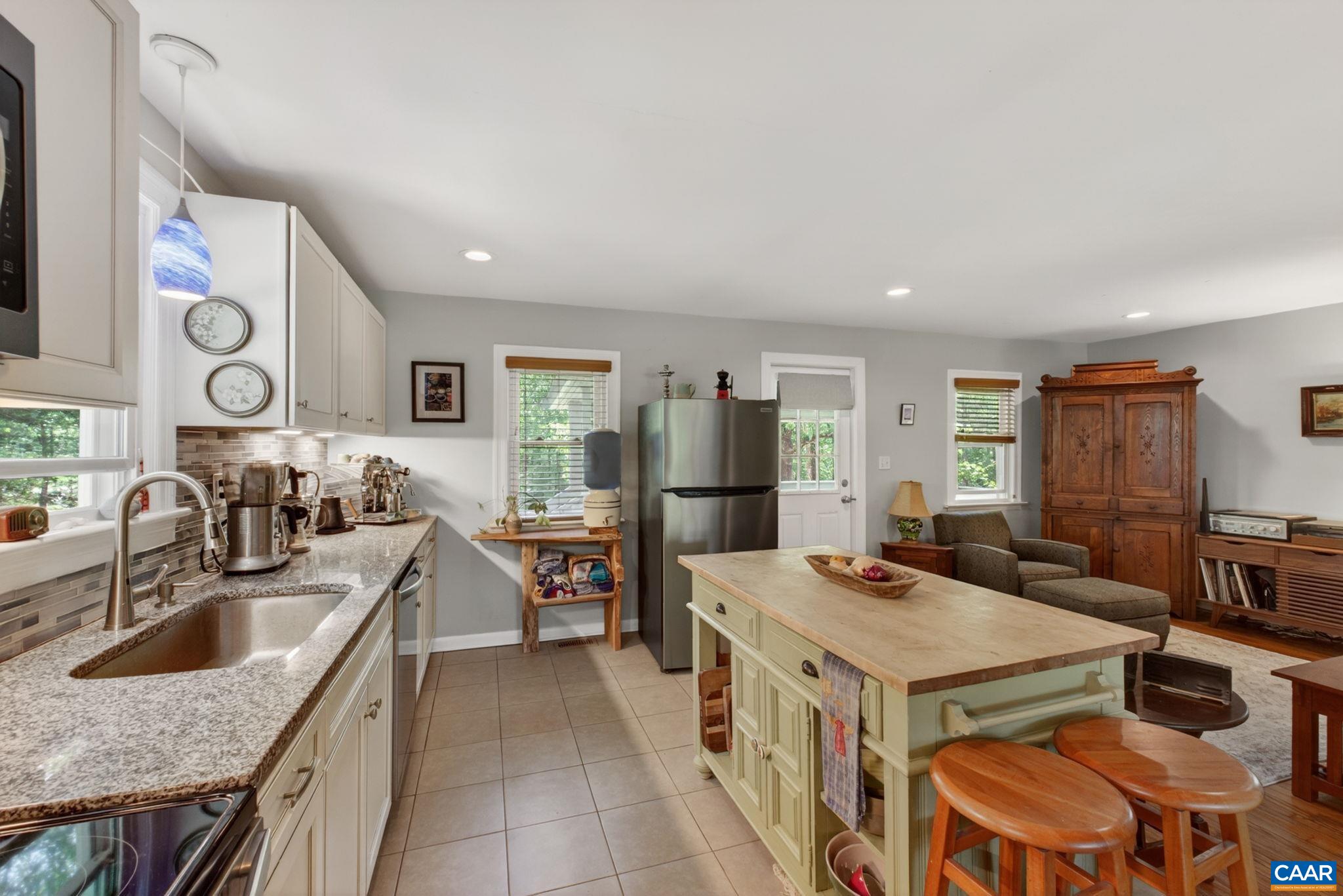 Kitchen with painted cabinets, granite counters and stainless appliances.