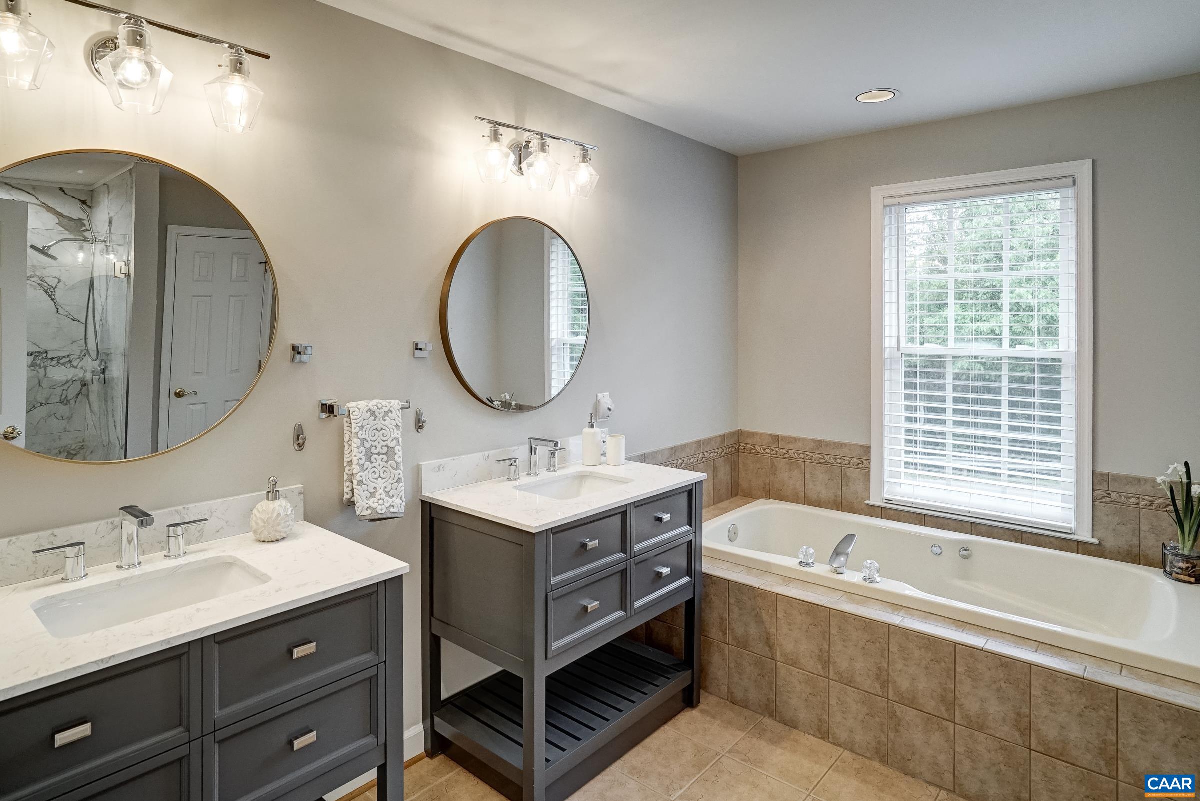 Updated primary bathroom with two separate vanities.