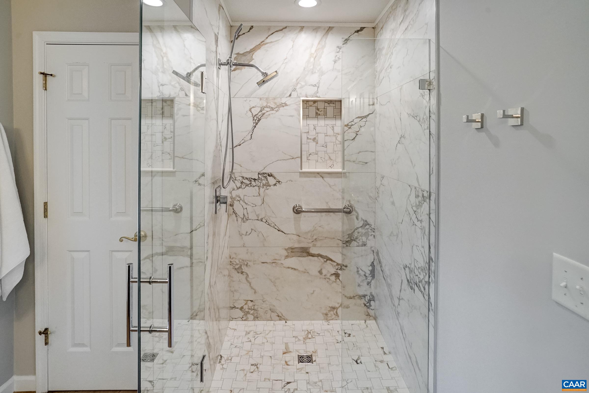 Updated shower with frameless glass doors.