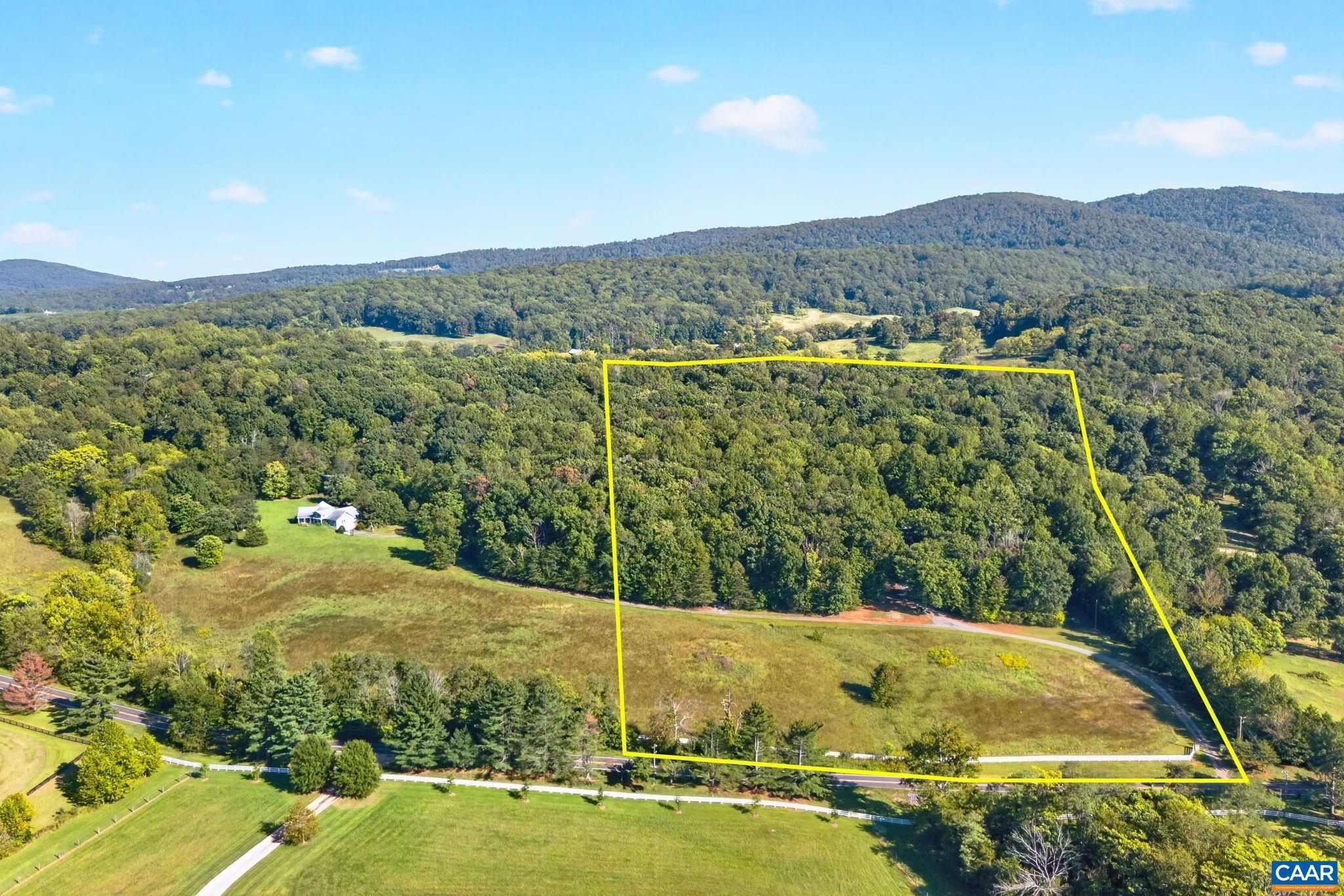 This view is showing the lay of the land with meadows in front and mostly hard wood trees in the rear.