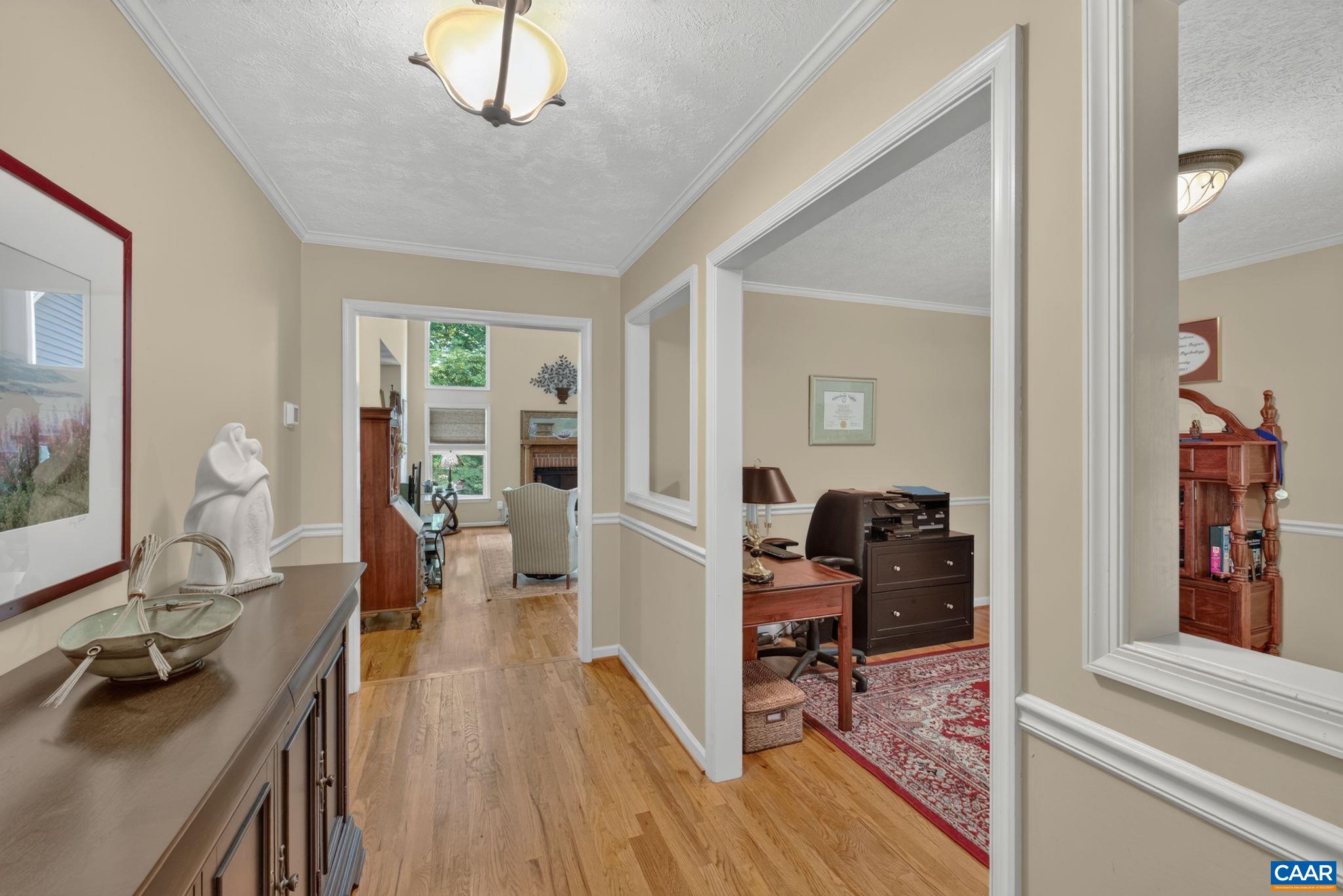 Showing the Formal Dining Room to the right and heading into the Great Room with 2 story cathedral ceiling.