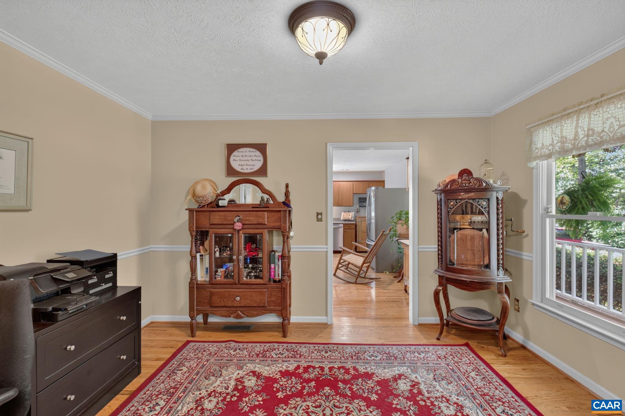 The formal Dining Room is currently used as an office.  View is also showing one of the entrances to the kitchen.