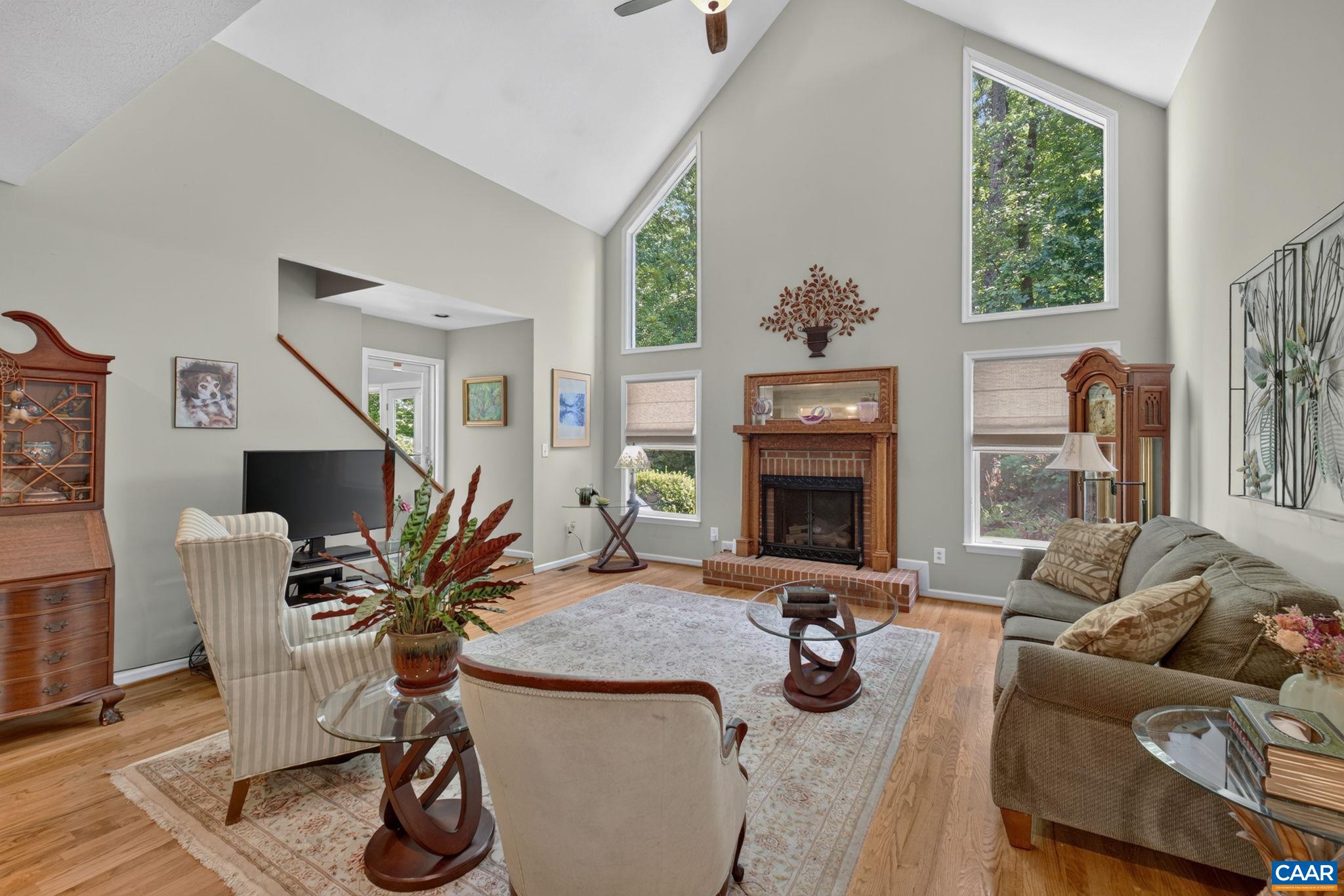 This spacious room features a cathedral with with a loft overlooking it plus a propane gas fueled Fire Place with an antique frame (easily removed if not your taste)  View also shows the doorway into the Four Season room.