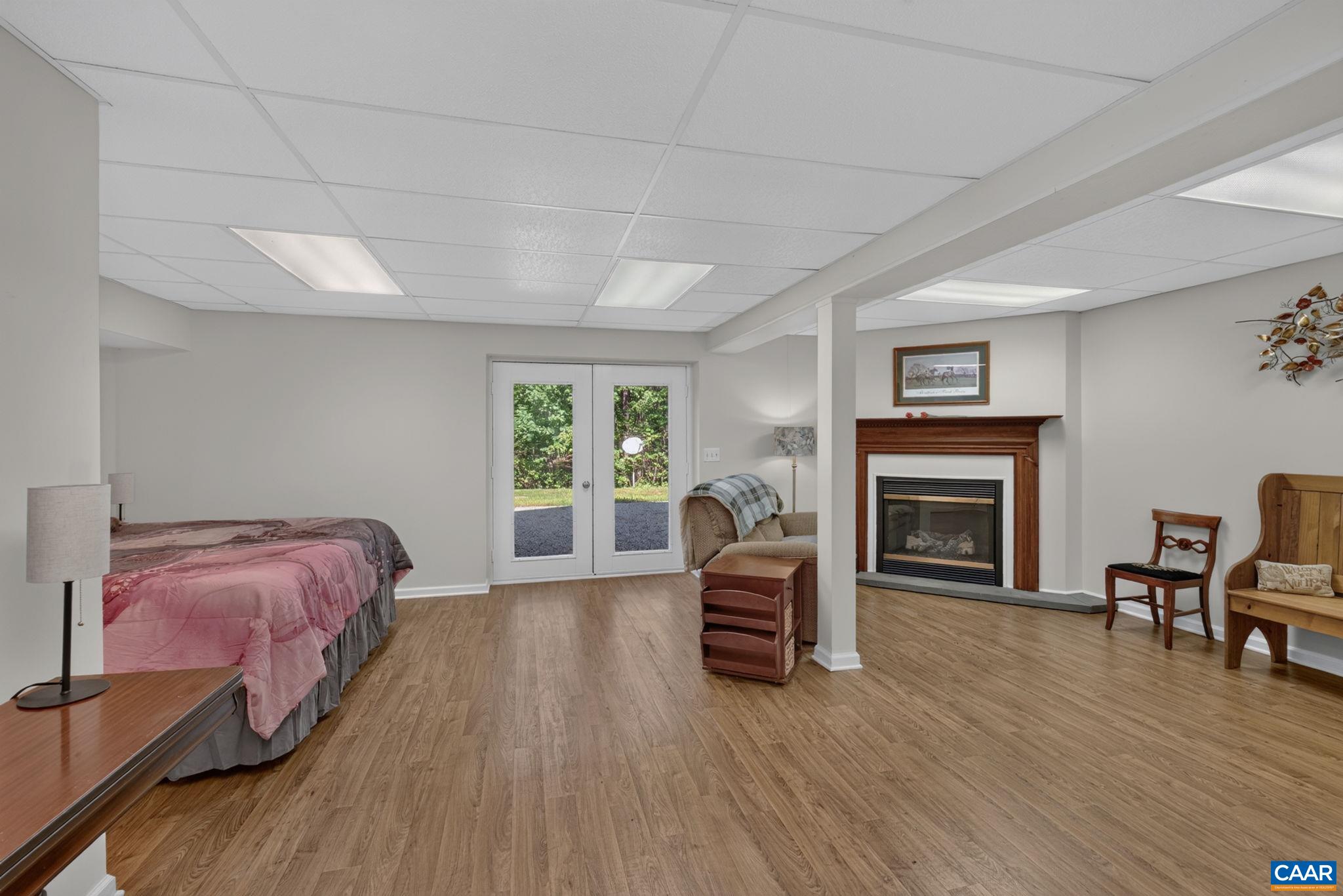 The flooring in this palatial space is brand new (2026).  Space could be used as a 4th bedroom, office, play area or whatever...the possibilities are endless.  French doors lead out of the walk out basement plus there is a propane gas fueled Fireplace.