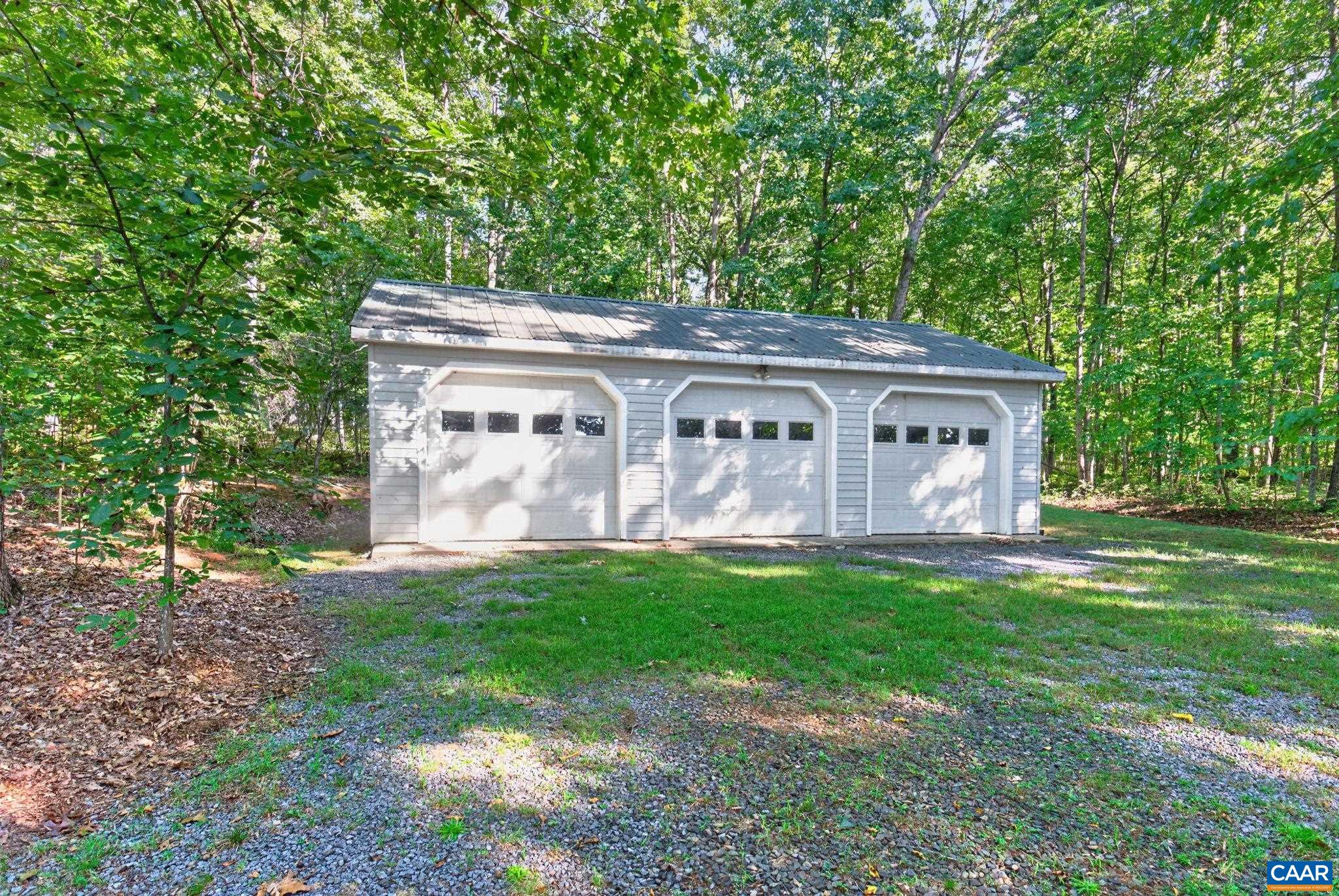 Another very spacious area with metal roof and a Wood Burning Stove inside plus workbenches. This could hold at least 6 vehicles or could be used for storage or multiple other uses.  This garage is being sold 