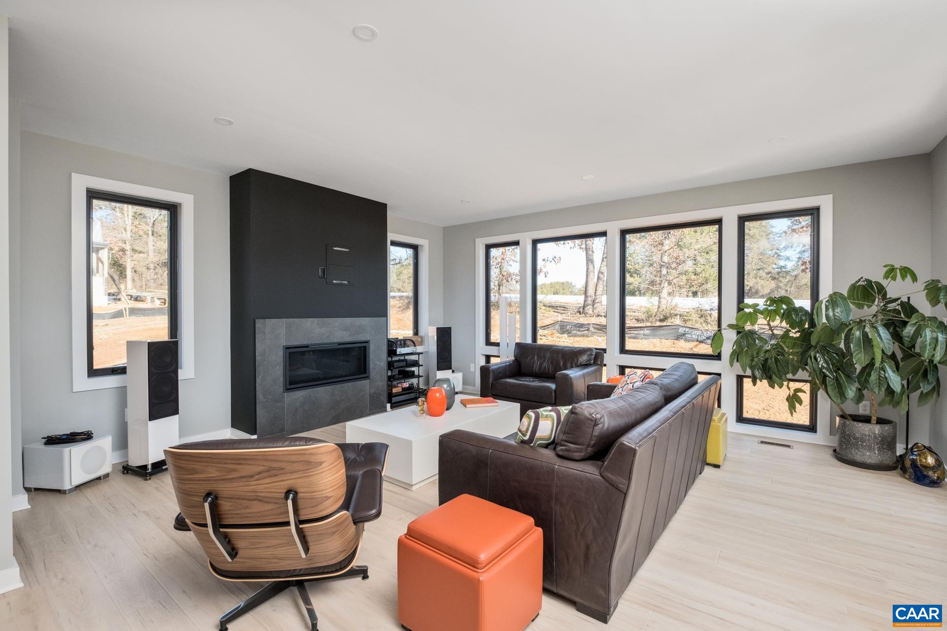 Large light-filled living room features statement fireplace with tile surround.