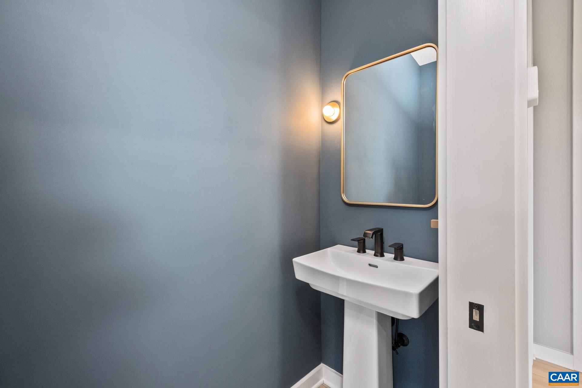 Main level half bathroom with pedestal sink and modern fixtures.