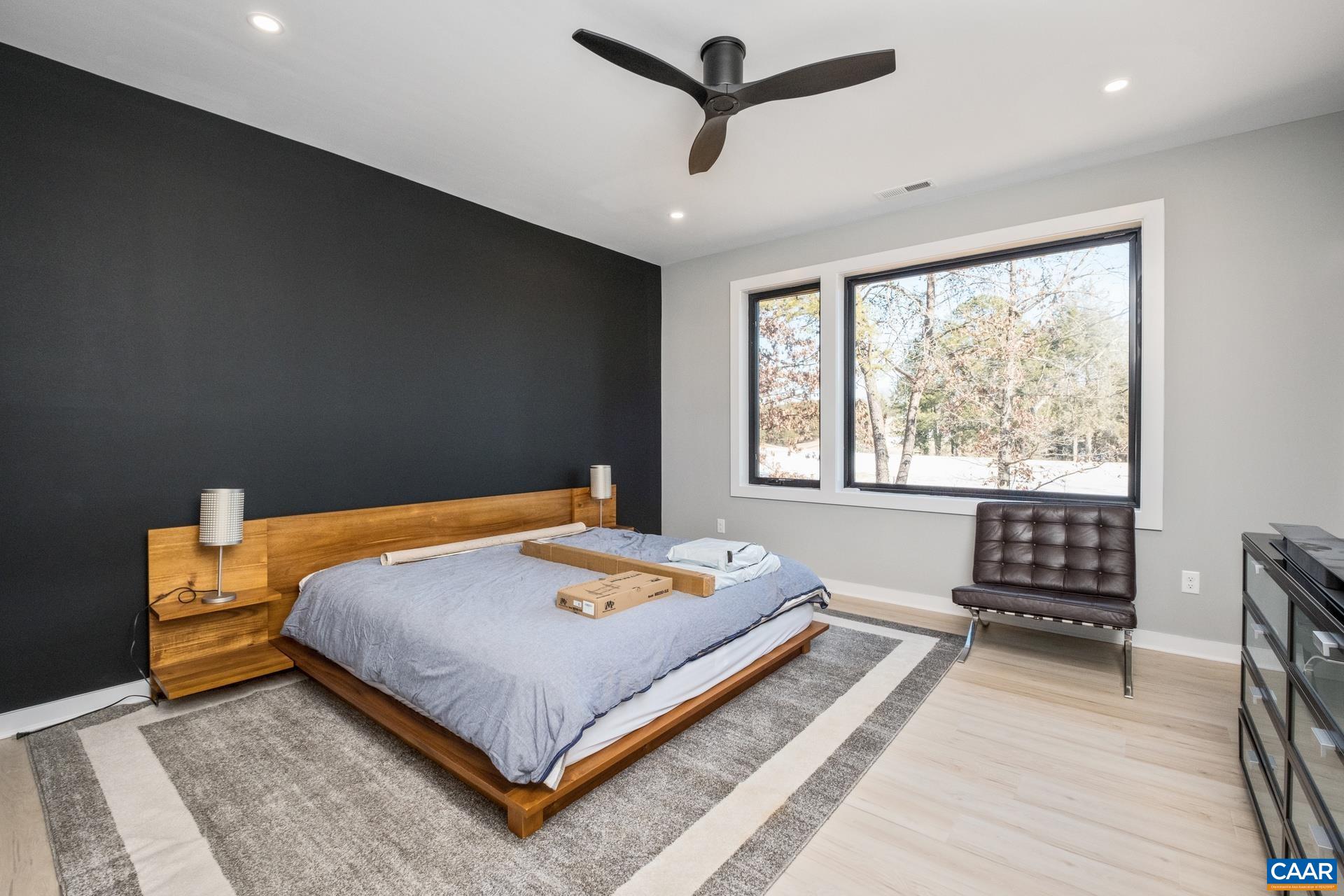 Primary bedroom with picture window, ceiling fan and ensuite bathroom.